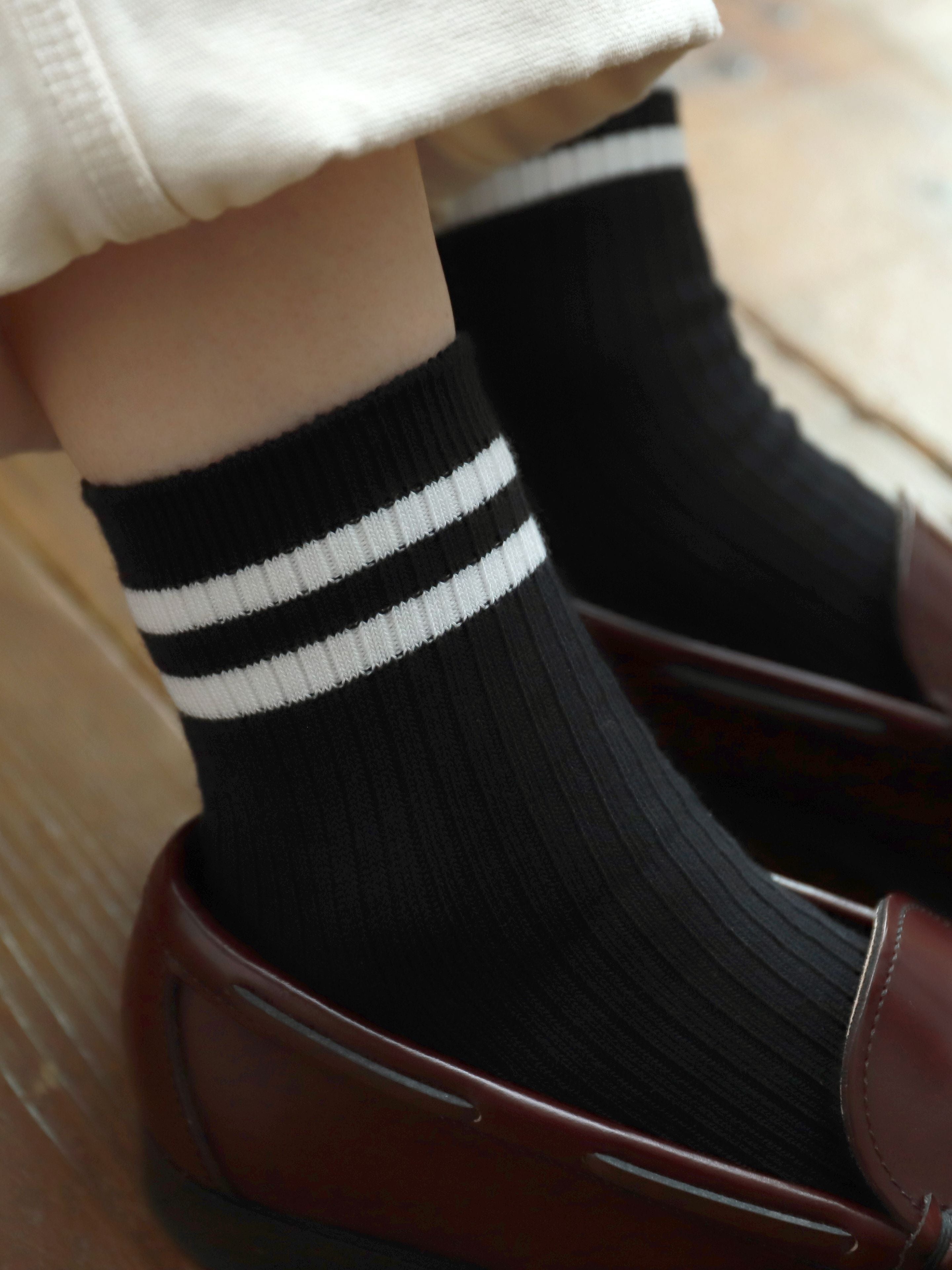 Tabio Neat Tennis Rib Ankle Socks in black, featuring ribbed texture and white stripes, styled with loafers for a sporty.