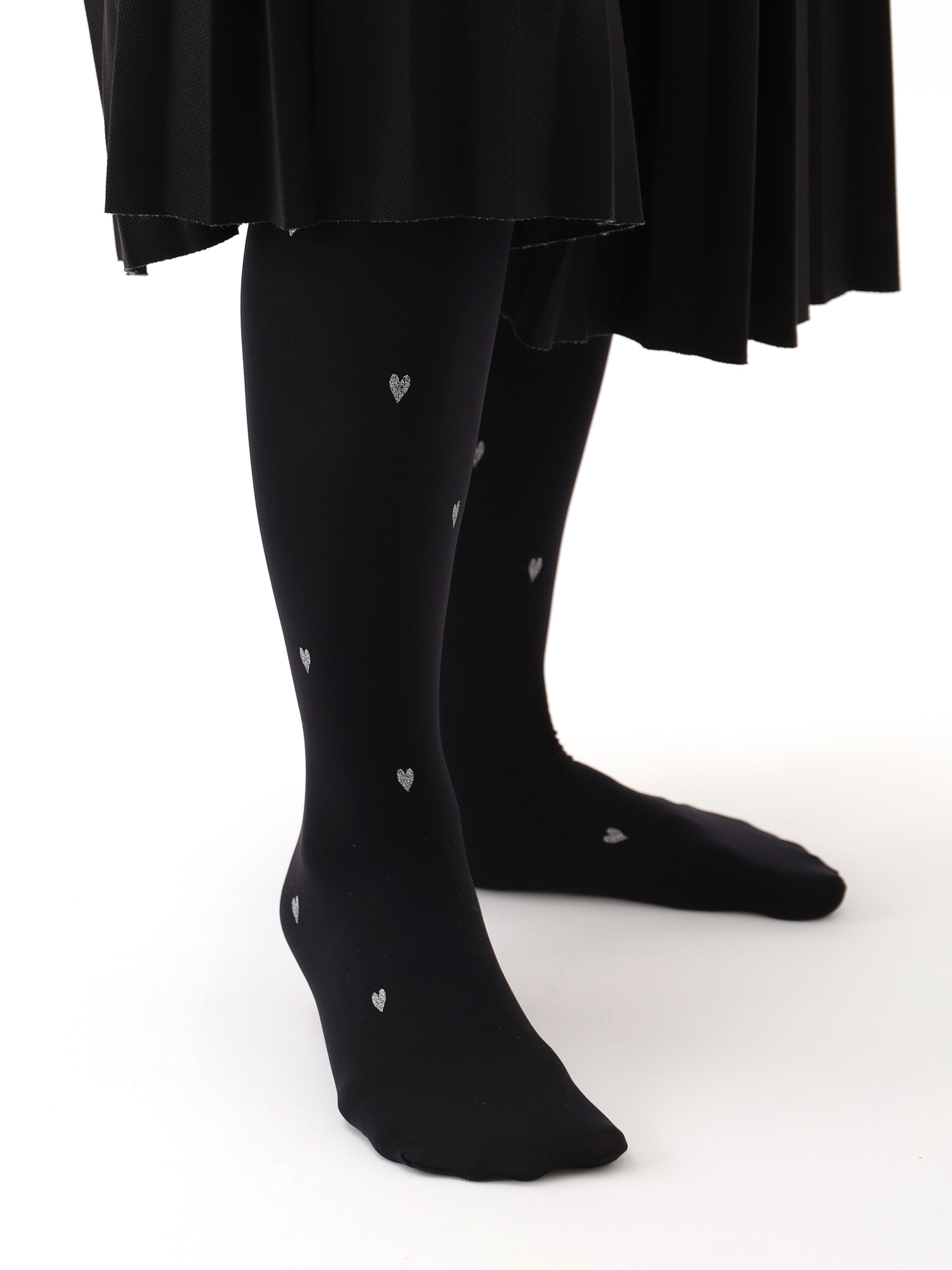 Tabio Heart Pattern Lamé 60D Tights feature a playful heart design in shimmering black and gold, styled on a model's legs.