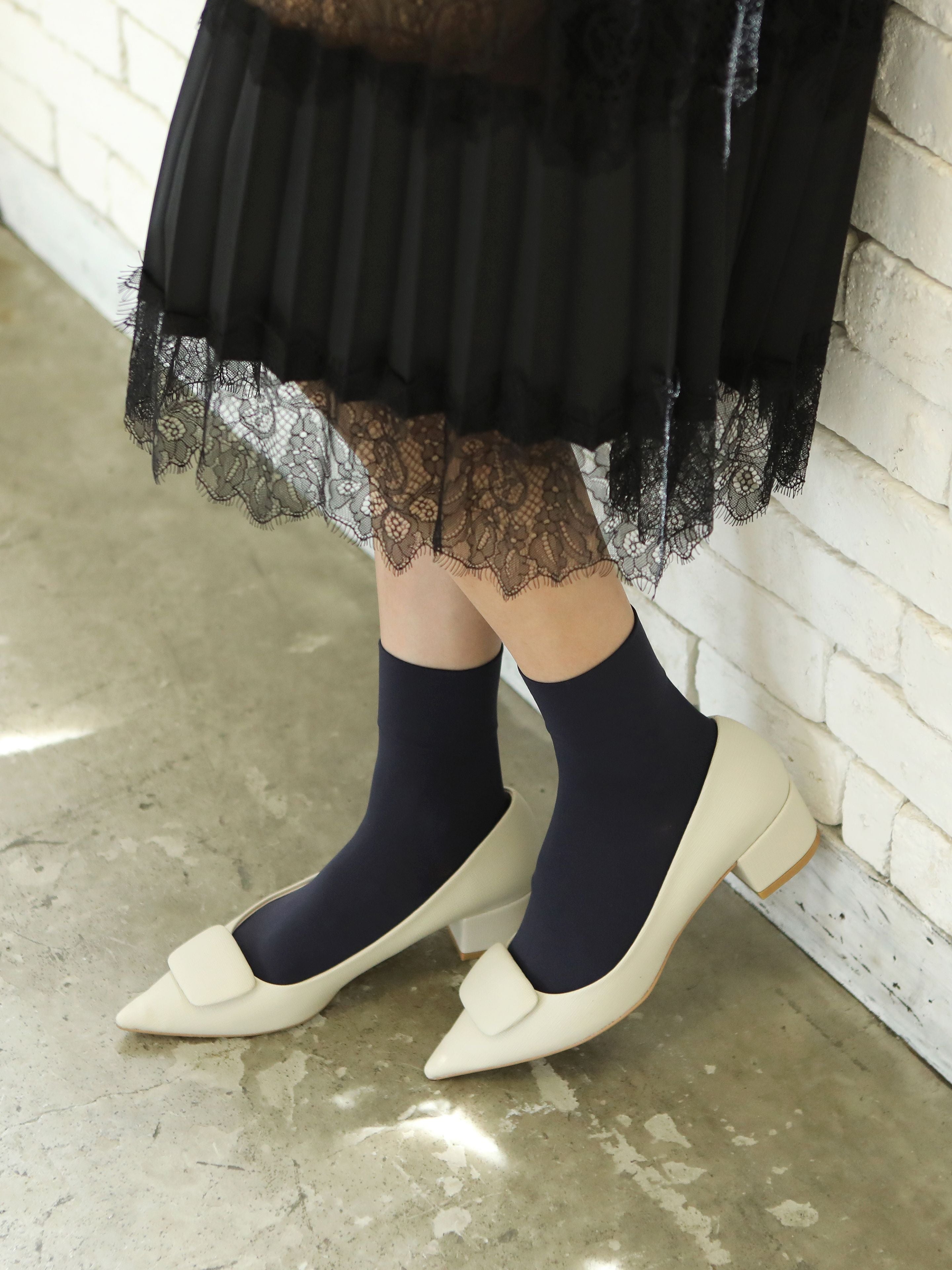 Tabio Soft Nylon Socks in black, showcased on model with sleek heels, highlighting stretchy texture and elegant style.