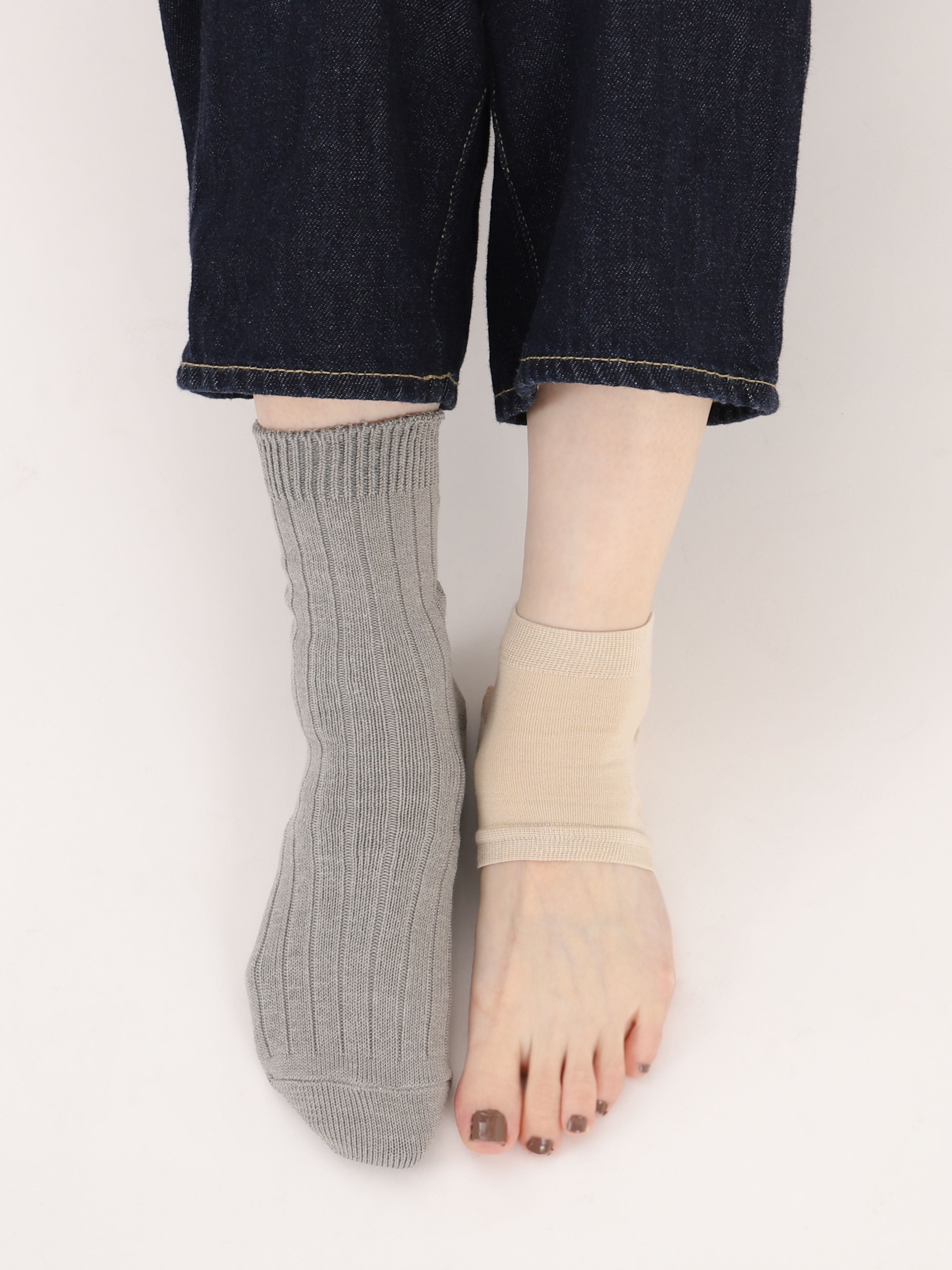 Tabio Moisture Heel Care Band on model, showing beige band for hydration alongside a gray sock, highlighting comfort and.