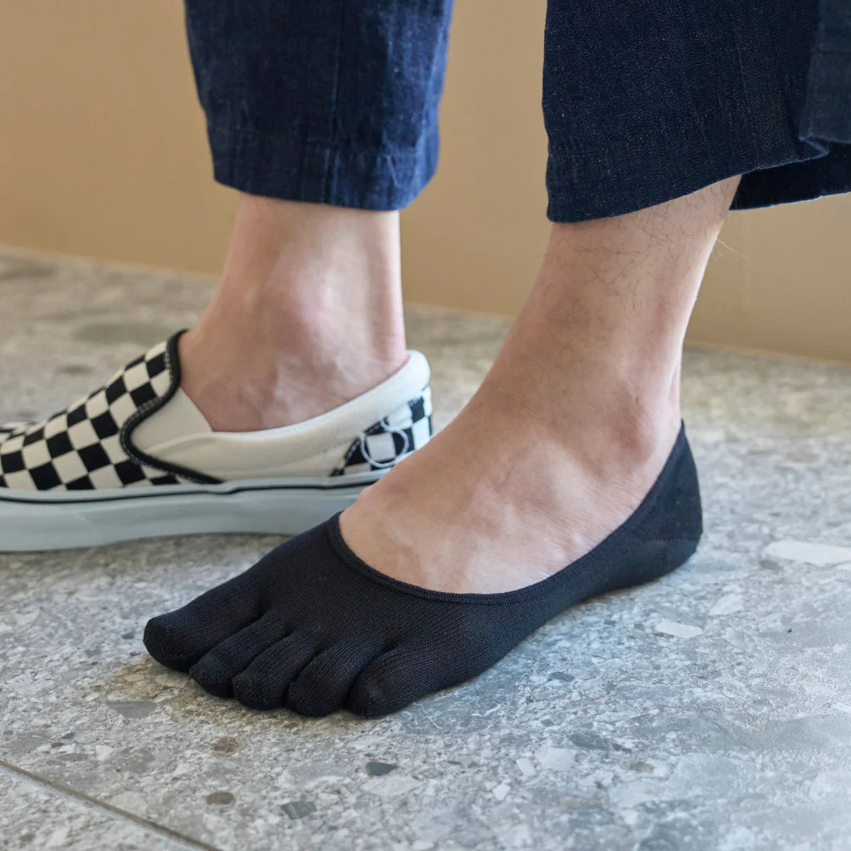 Model wearing Tabio Lyocell Toe No-Show Socks in black, highlighting their sleek fit and moisture-wicking fabric for.