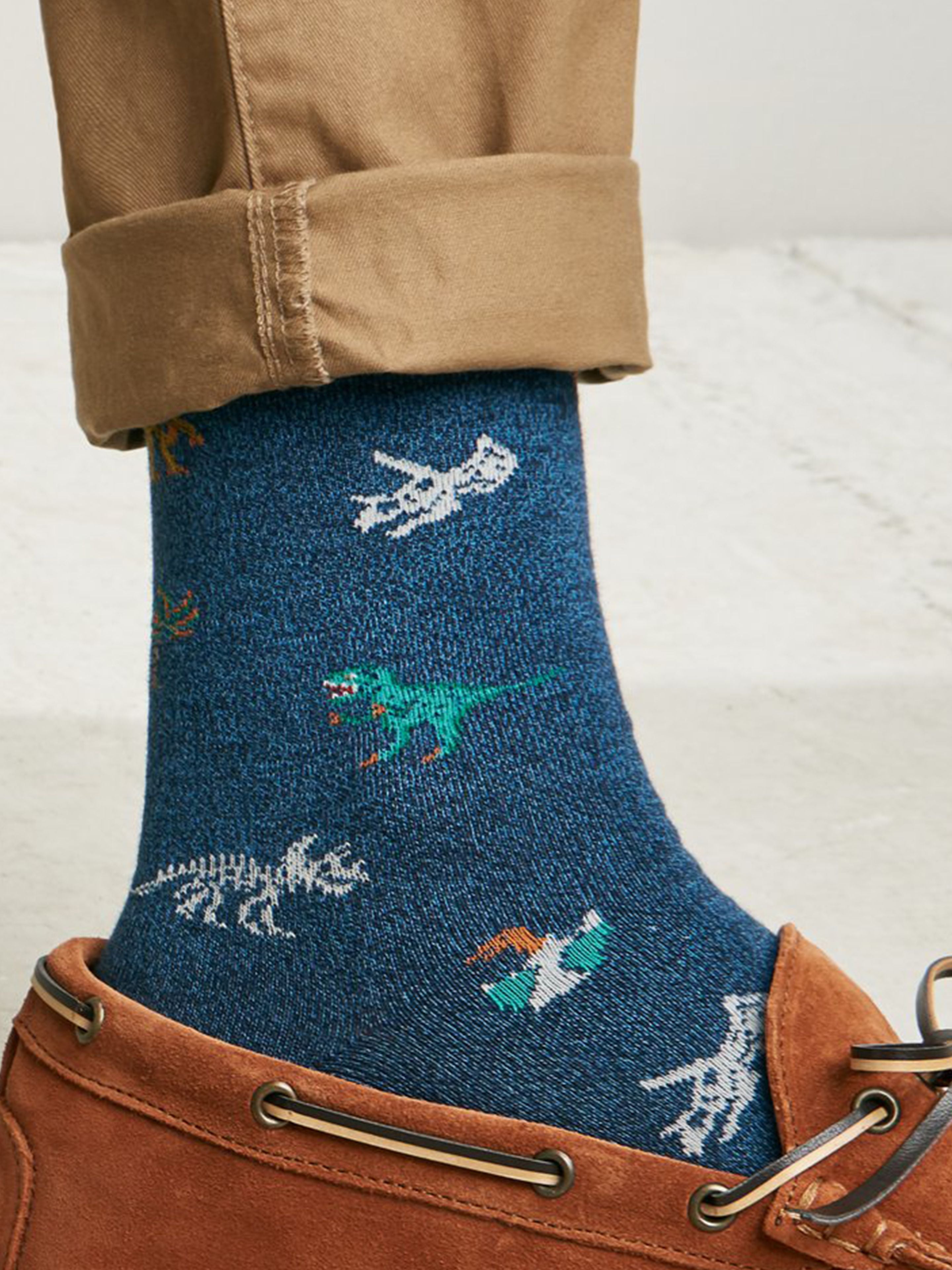 Tabio Dinosaur-Pattern Crew Socks showcasing colorful dinosaur motifs on a navy background, worn with rolled khaki pants.