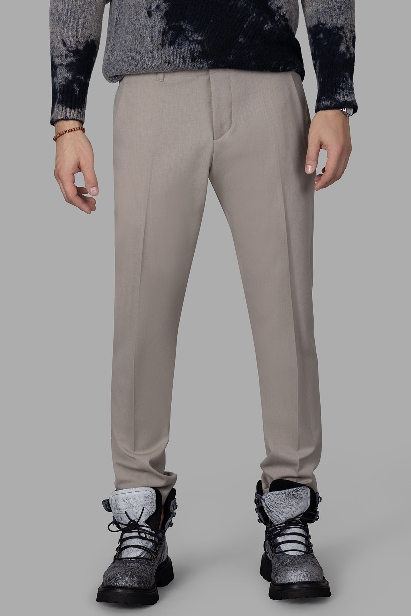 Gaëlle Paris Front-crease Trousers in beige, featuring side pockets and a sophisticated front pleat, displayed on a model.