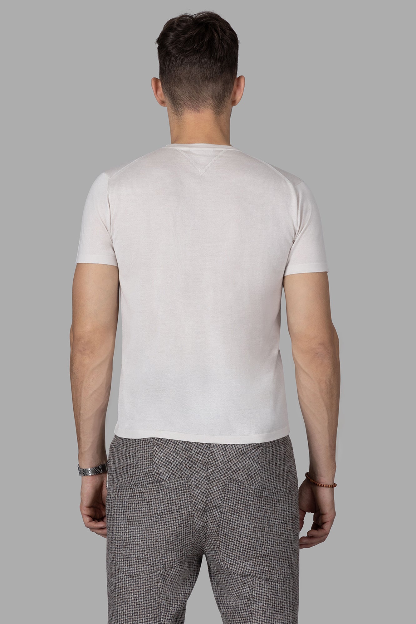 AION. Fine-knit T-shirt featuring a slim fit, rounded neckline, and short sleeves in cream, shown from the back.