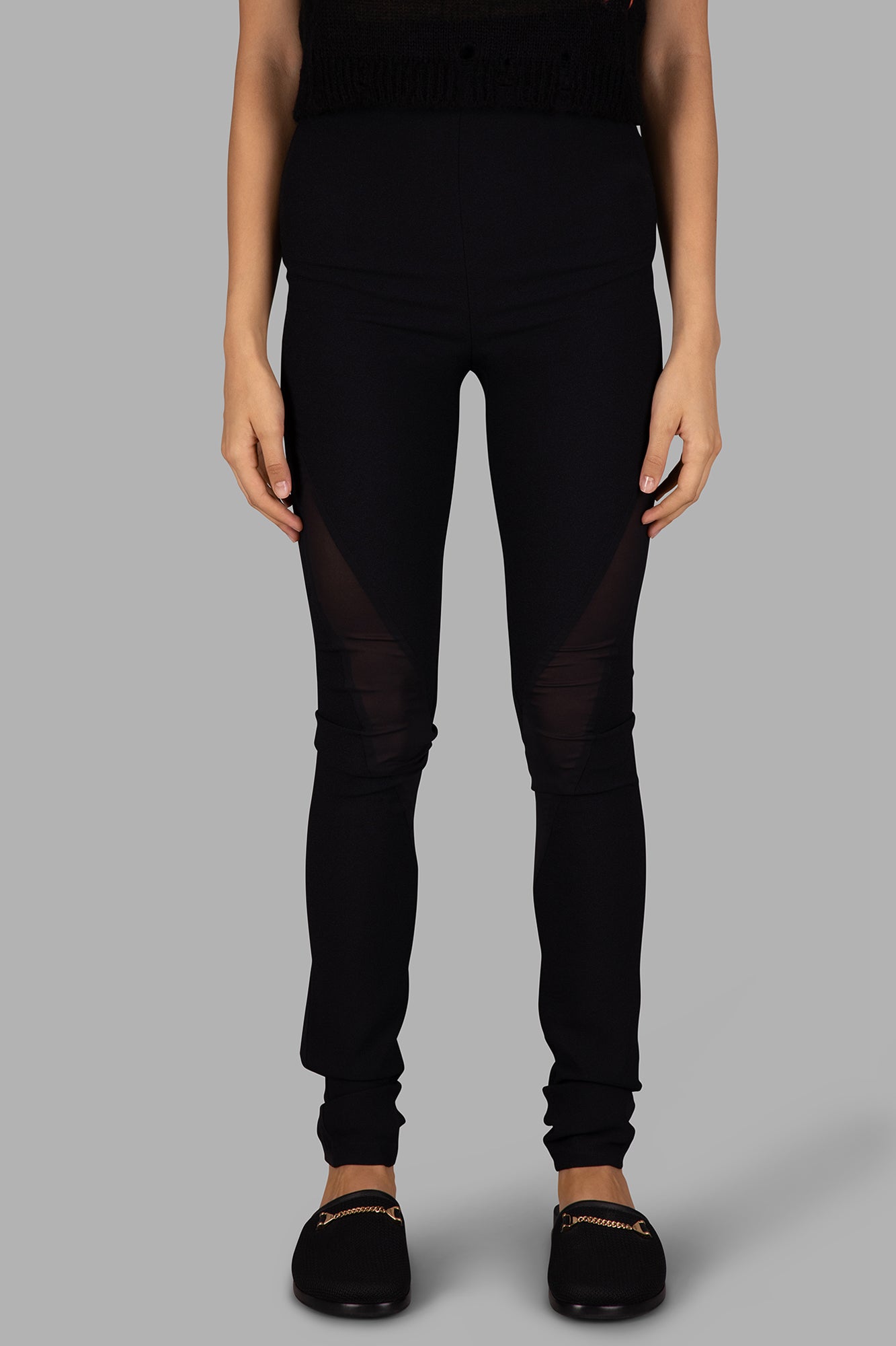 Giovanni Cavagna's black skinny-leg trousers with sheer side details, showcased on model from a side perspective.