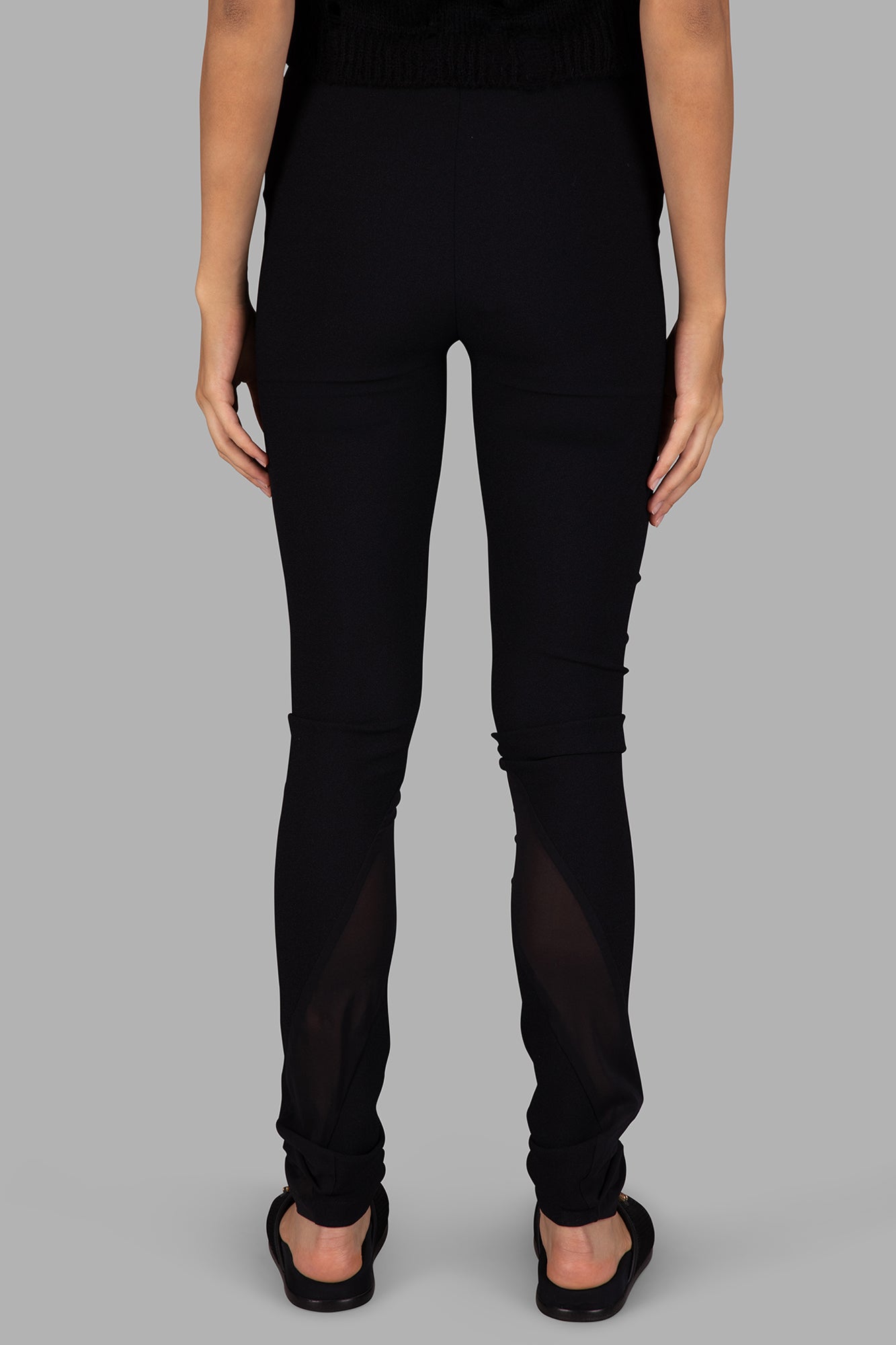 Giovanni Cavagna Skinny-Leg Trousers in black, showing back with high-waisted design and sheer panel details.