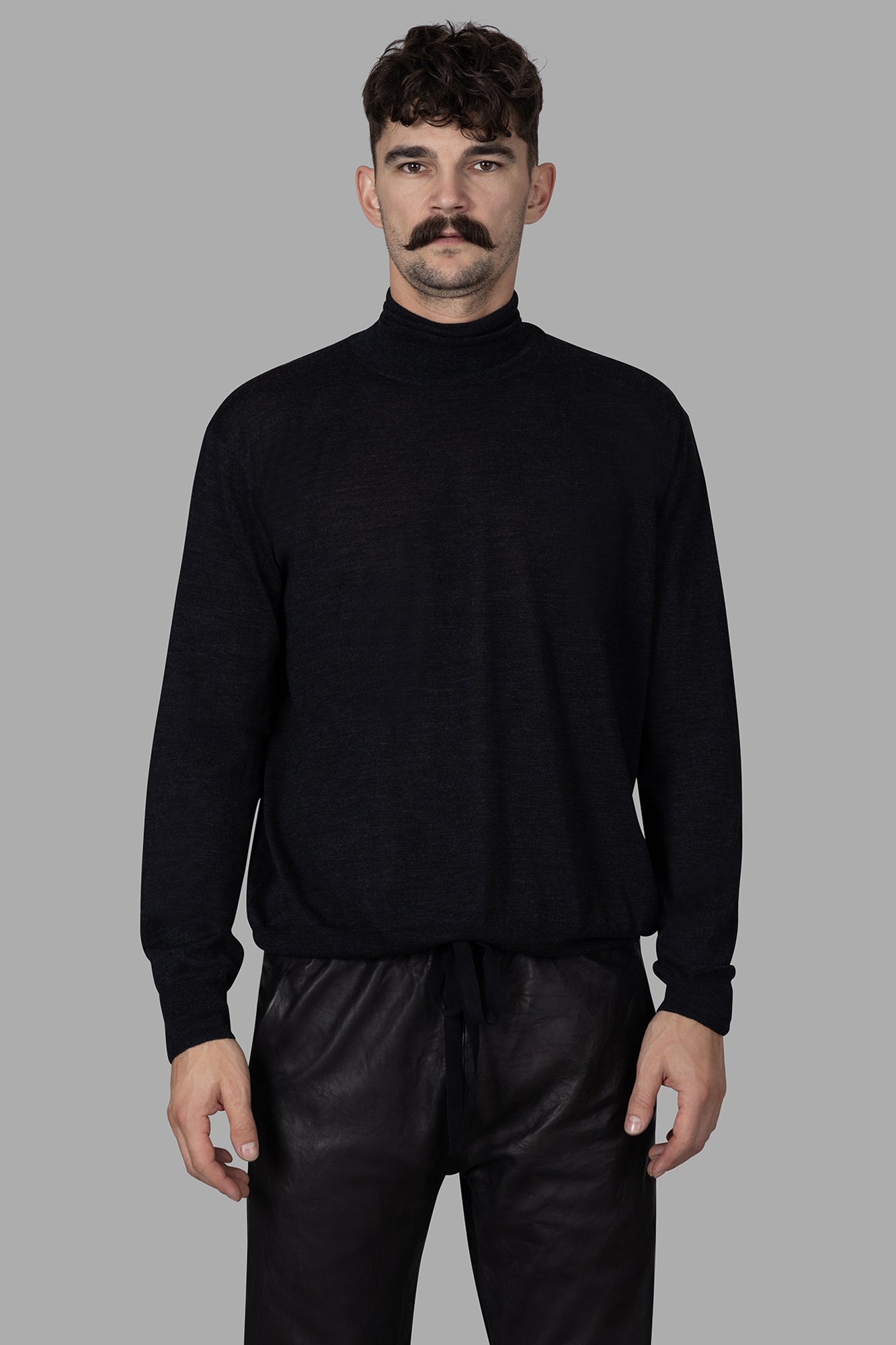 AION Fine-knit Turtleneck Sweater in antracite, featuring a cozy fit and luxurious virgin wool, worn on a model.