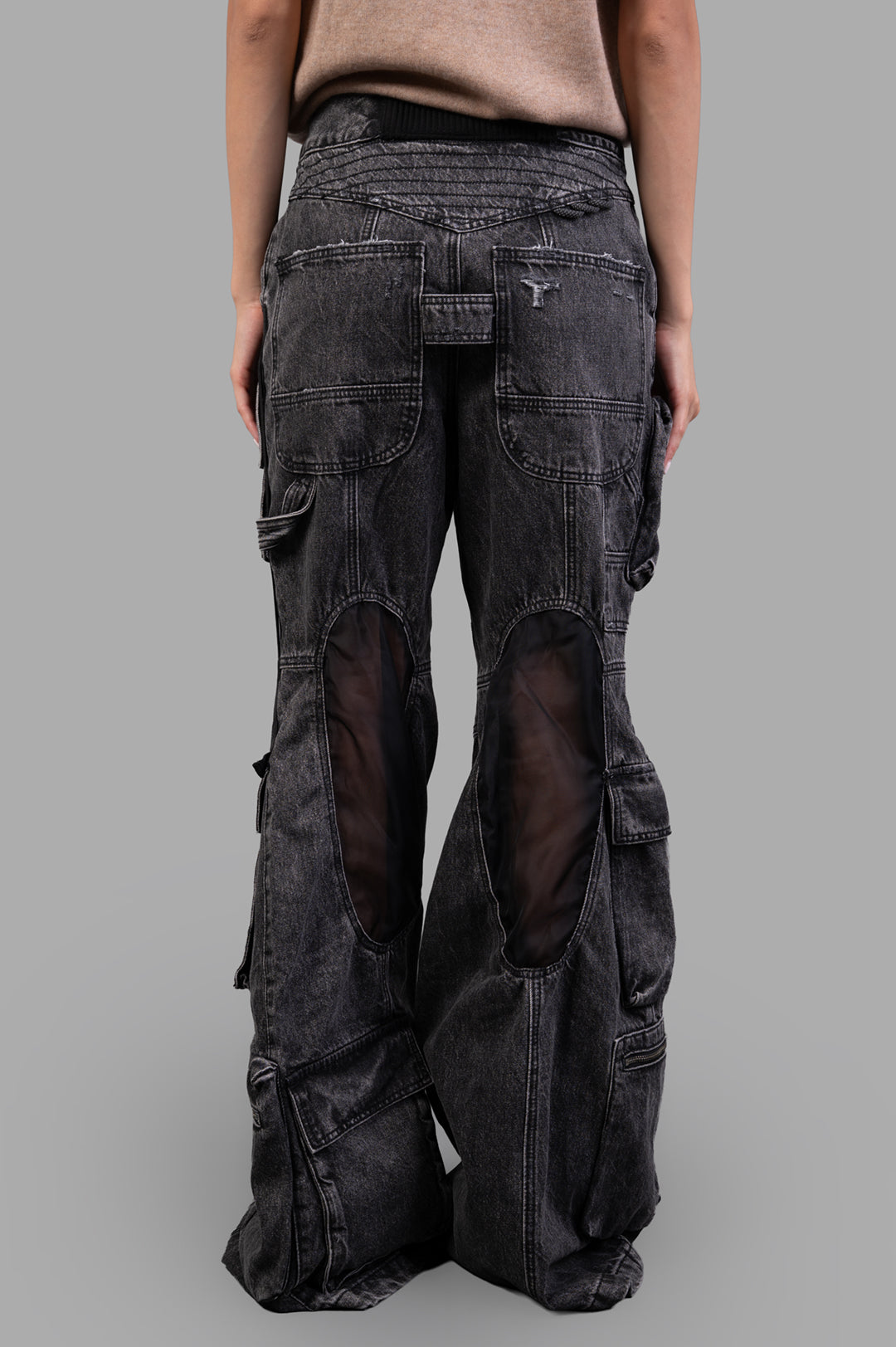 **Alt Text:** Natasha Zinko Camping Cargo Jeans shown from the back, featuring unique cutouts and detailed pocket design.