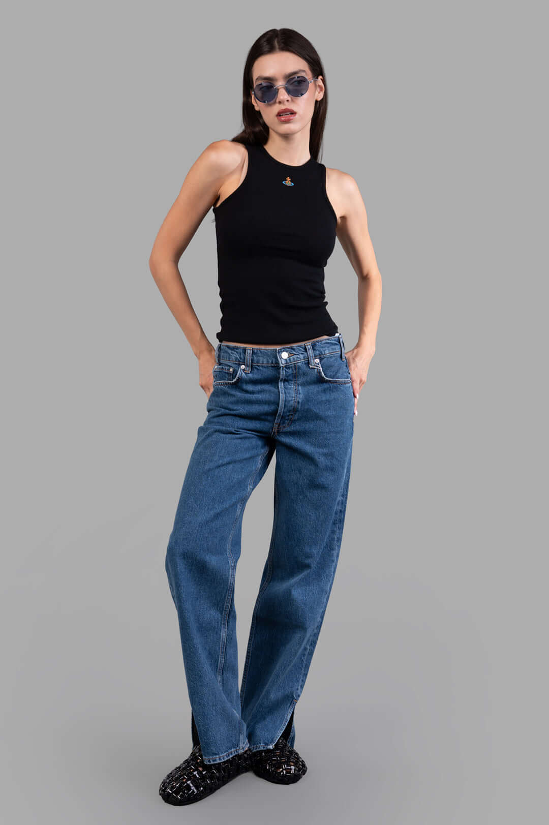 Vivienne Westwood 90s Vest in Black, front view on model; ribbed tank with high neck, small chest logo, styled with jeans