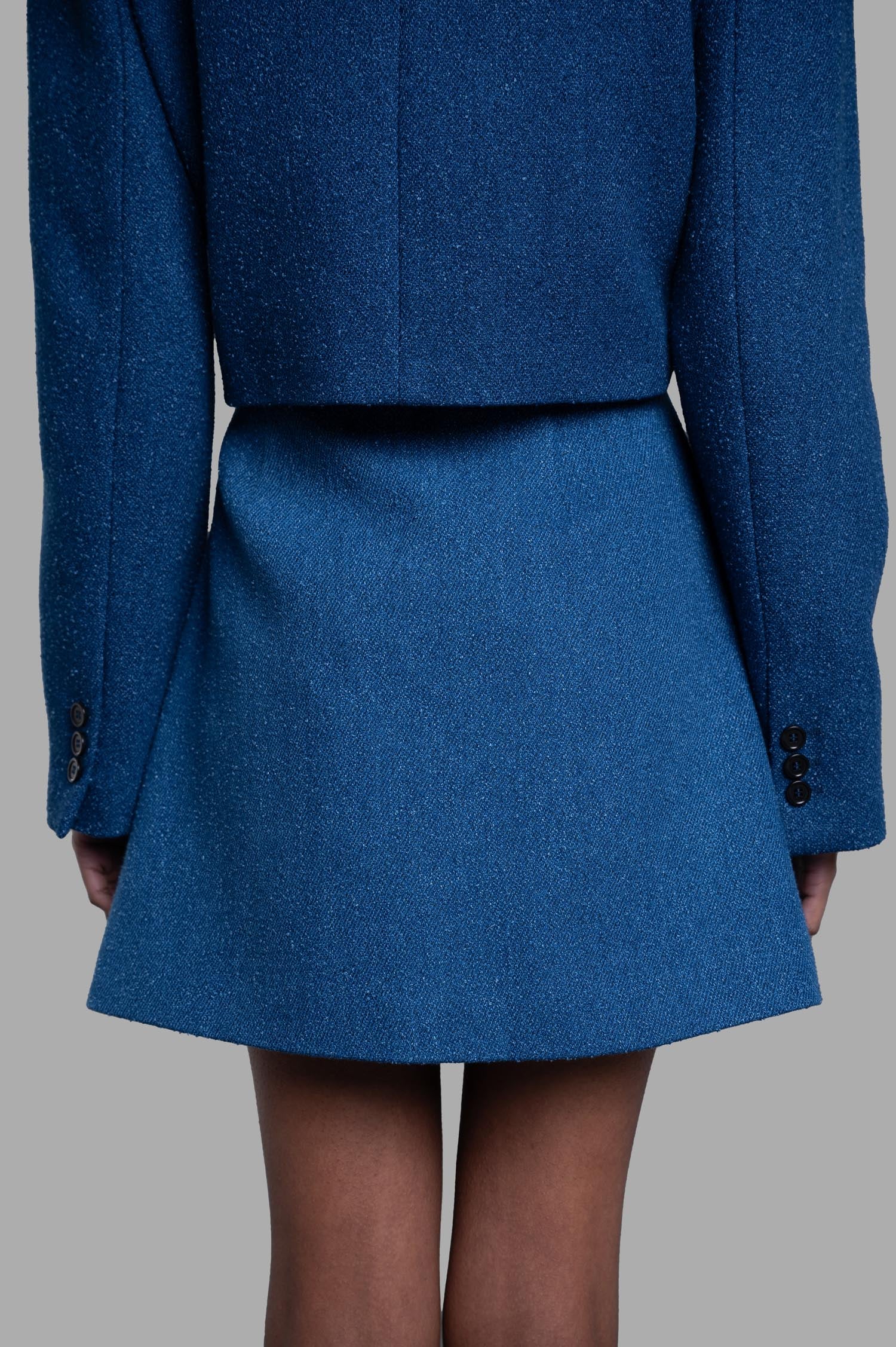 MSGM A-line Mini Skirt back view on-model in blue tweed, high-waist flare silhouette, shown with matching blazer.