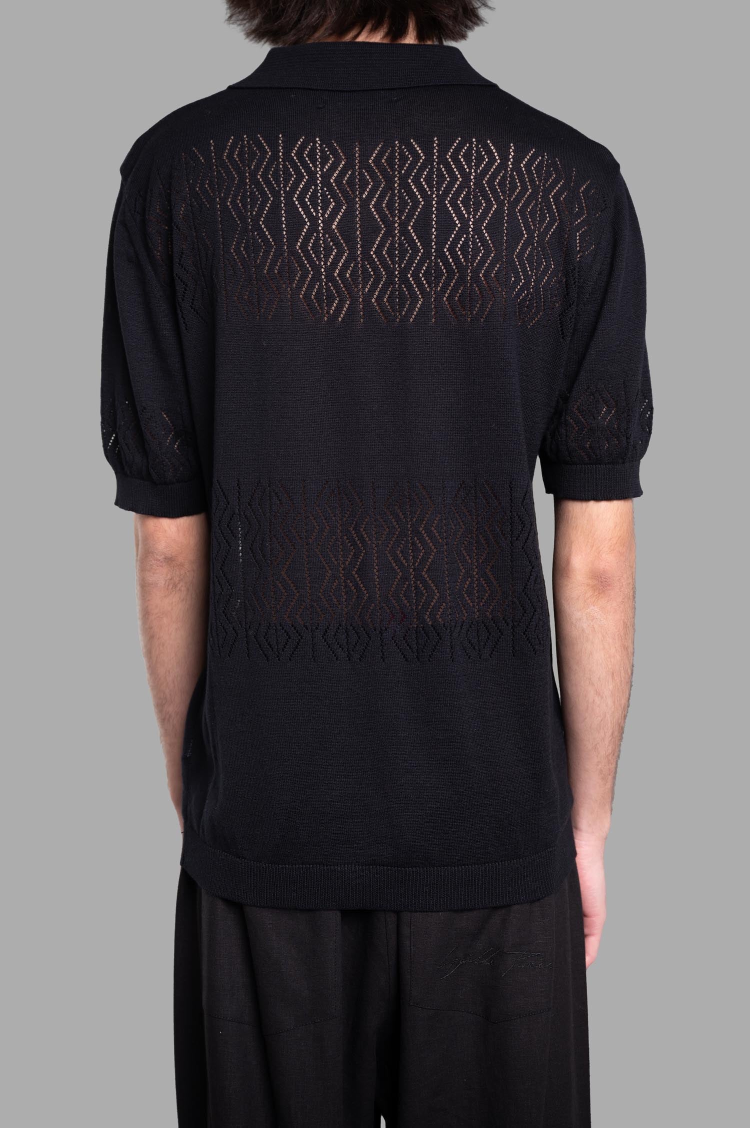 Gaëlle Paris Knit Polo Shirt showcasing a stylish open back design with intricate texture in black, perfect for relaxed wear.