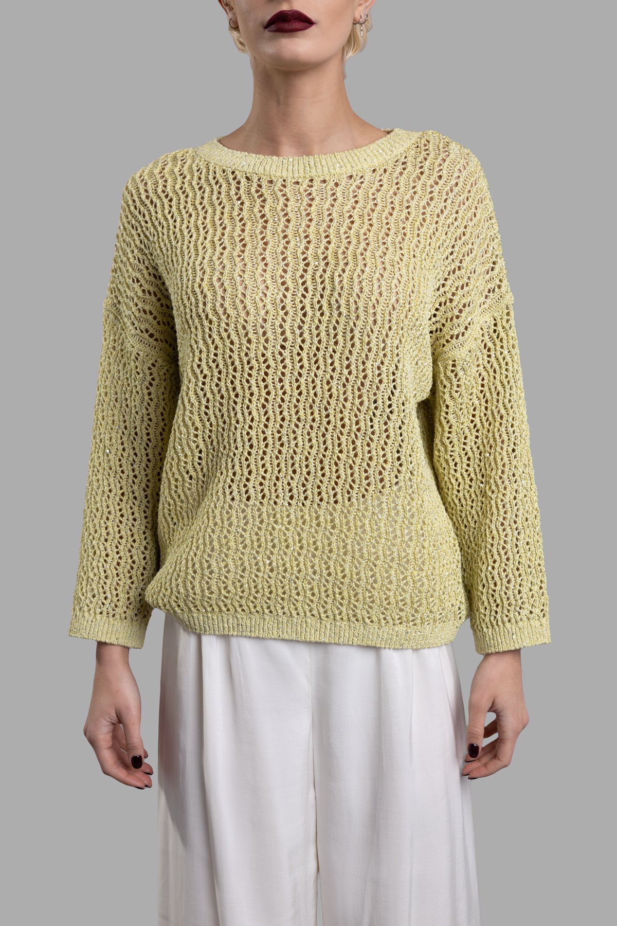 Gentry Portofino Lime Sweater featuring a loose, textured knit design and round neck, worn with tailored white pants.