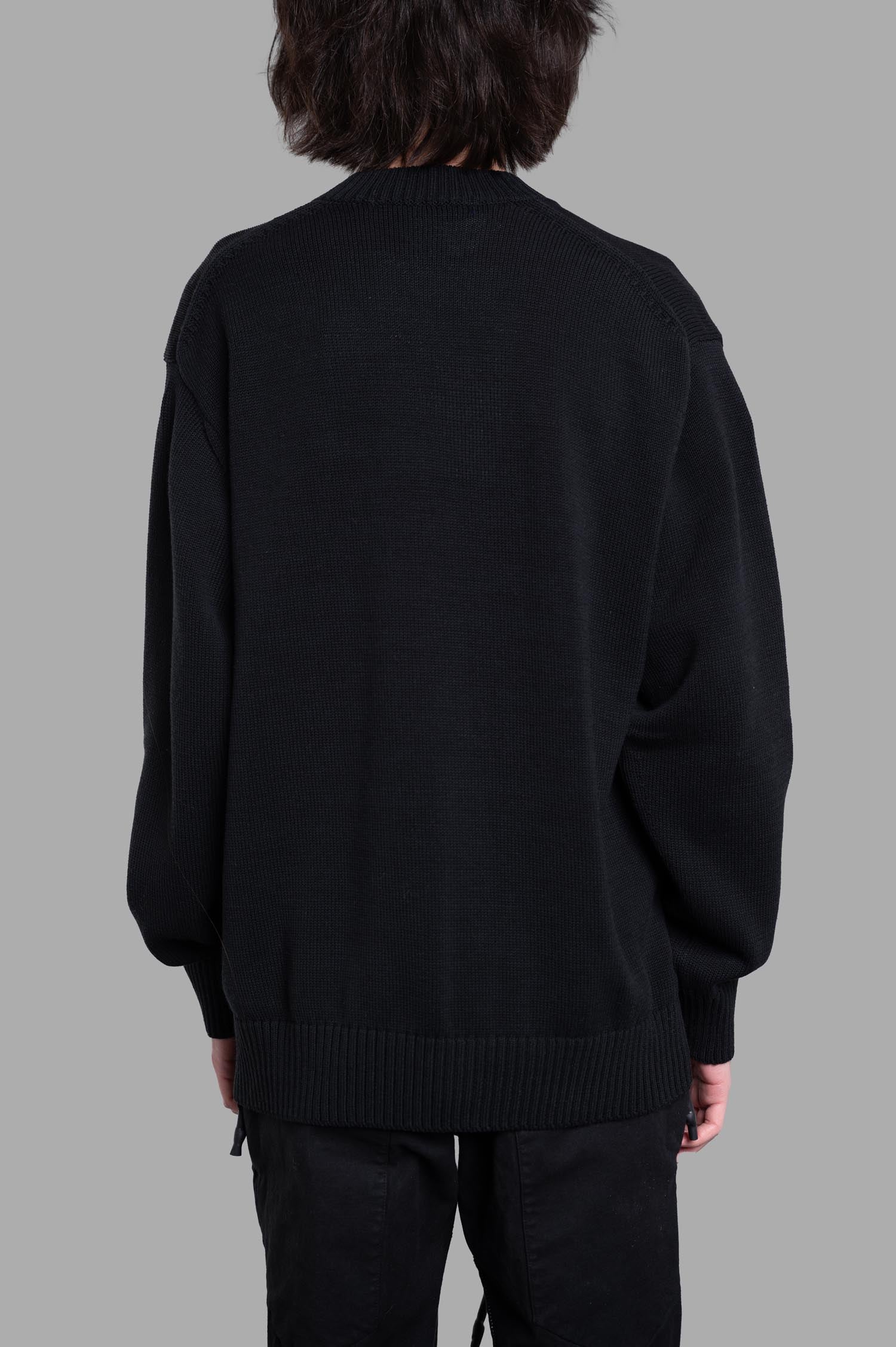 Junya Watanabe Patchwork Sweater, back view showing the relaxed fit and ribbed hem in soft black cotton. Perfect for.