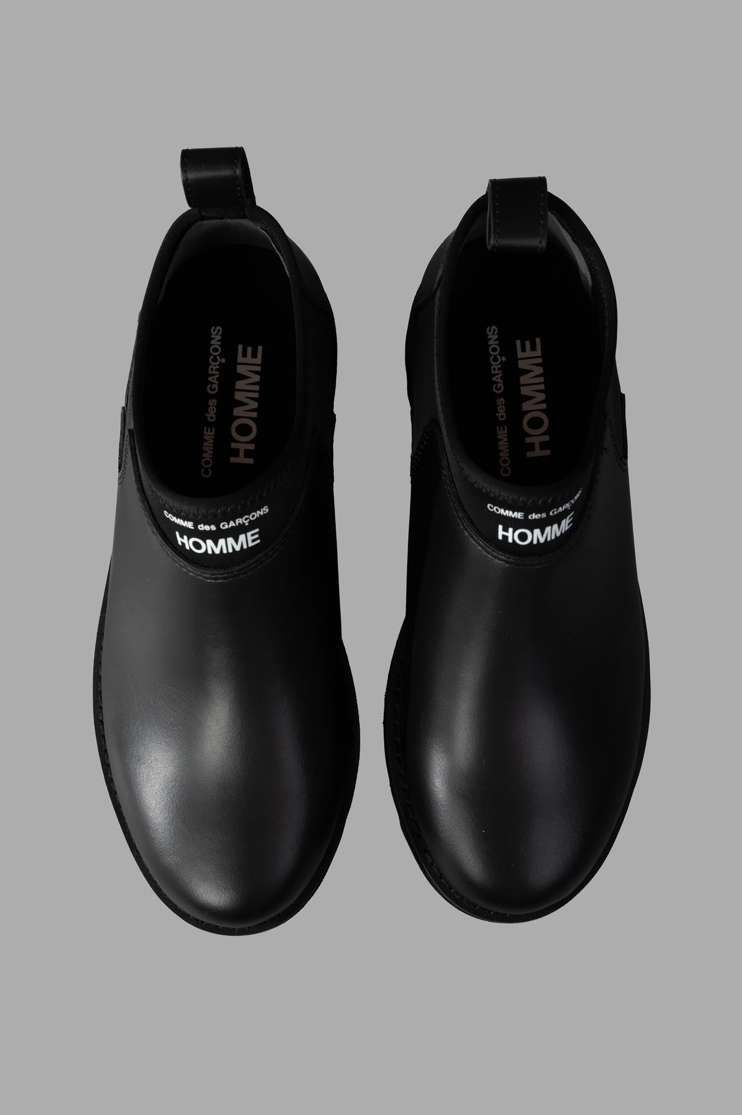 Comme des Garçons Logo Leather Boots view from above, showcasing smooth black leather and branded insole for added style.