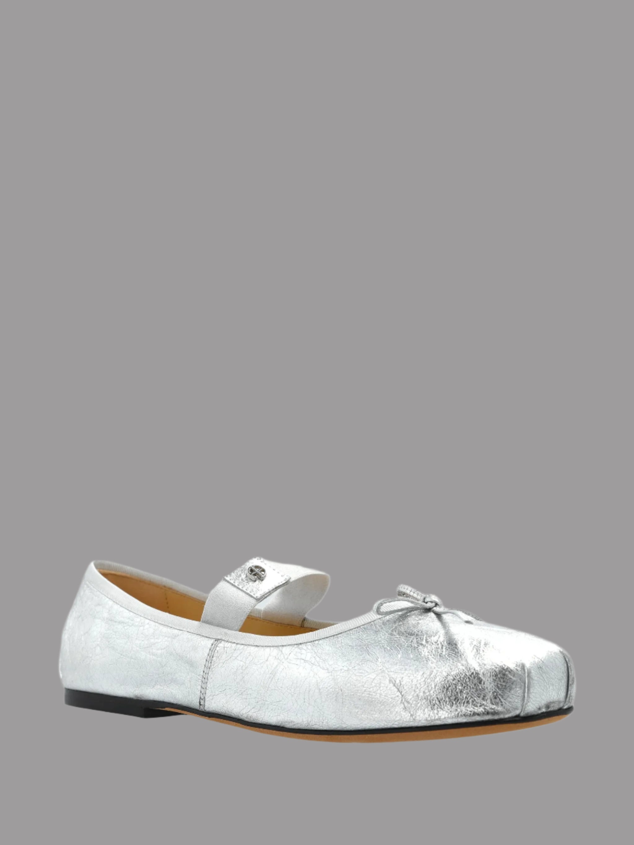 Anine Bing Jolie Flats in silver, featuring a rounded toe, leather bow, and secure elastic strap viewed from the side.