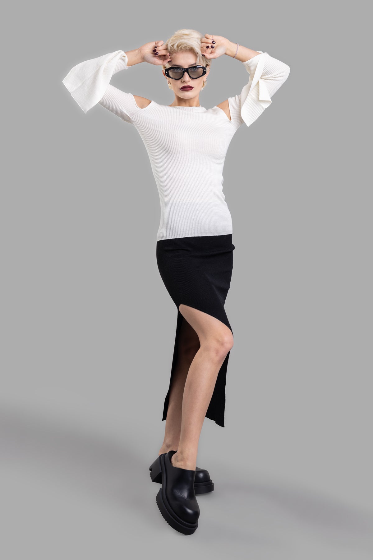 Rick Owens Ziggy Skirt in black, side view. Floor-length with knit waistband and side split above knee. Worn by model.