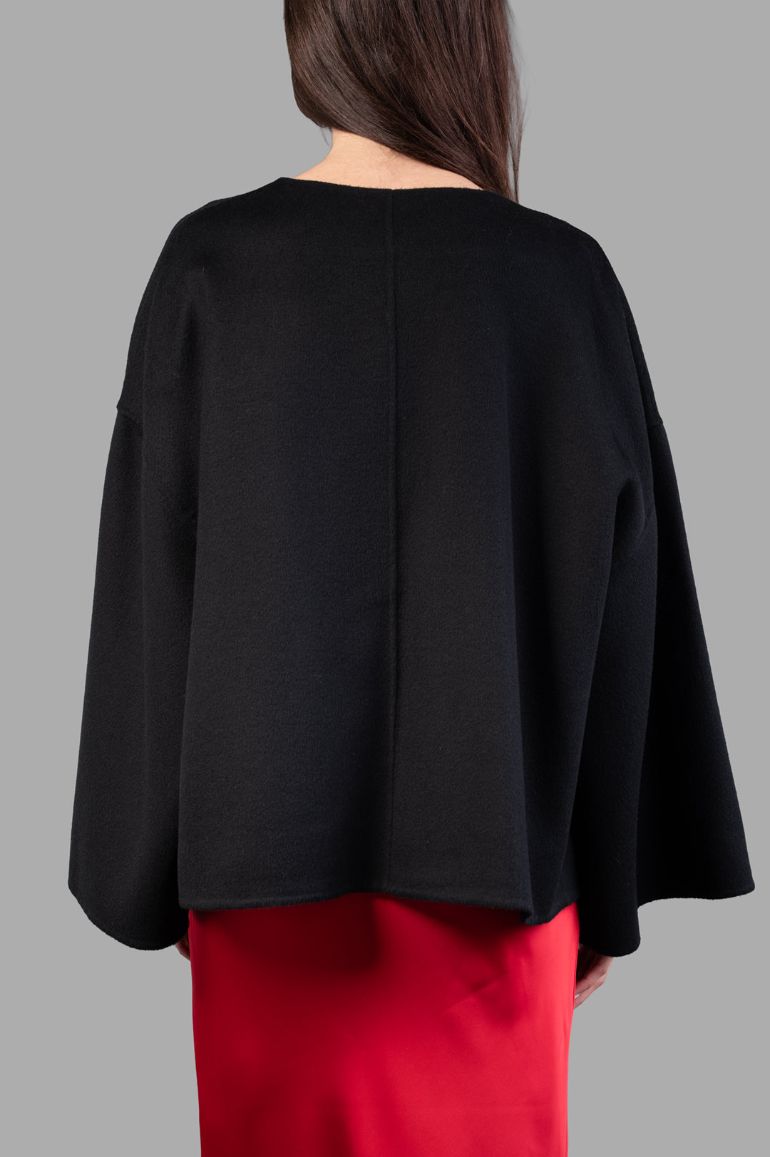 By Malene Birger Jacquie Wool Jacket displayed on model, showcasing a sleek black design with a relaxed fit and unique back.