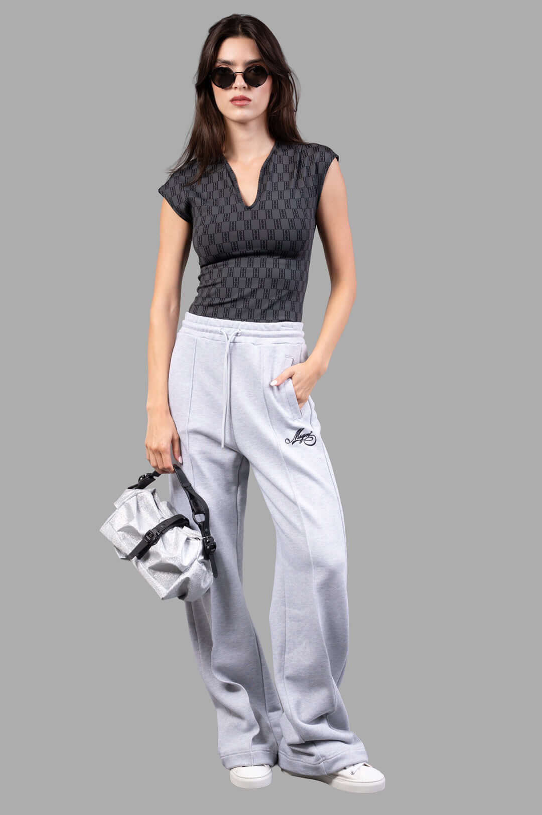 By Malene Birger Venazia Athletic Top in black and grey, front view, V-neck, worn with grey pants and a handbag.