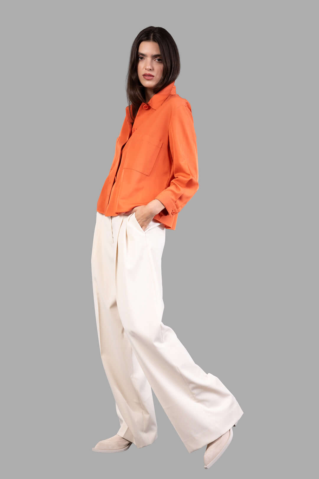 By Malene Birger Cymbaria High-waist Trousers in pearl color, front view on model, showcasing wide-leg and pleated design.