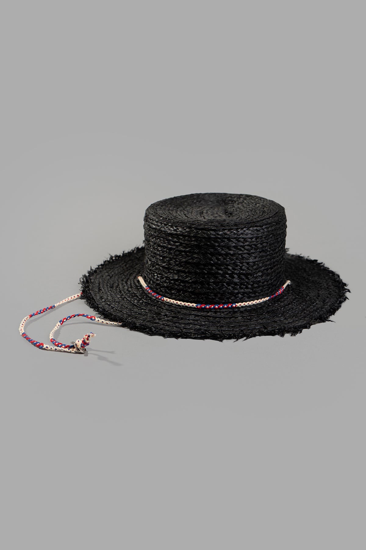 Kijima Takayuki Black Straw Boater Hat front view with colorful chin cord detail on a gray background.