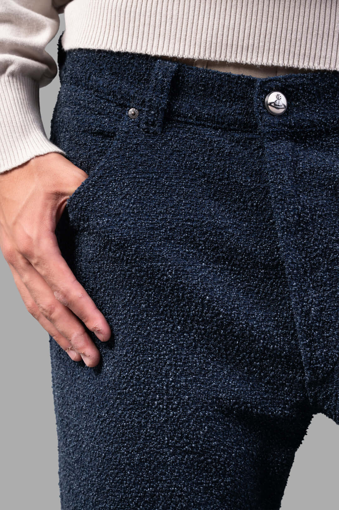 Vivienne Westwood Ranch Bouclé Wool Jeans close-up of textured fabric and branded top button, styled with a sweater.