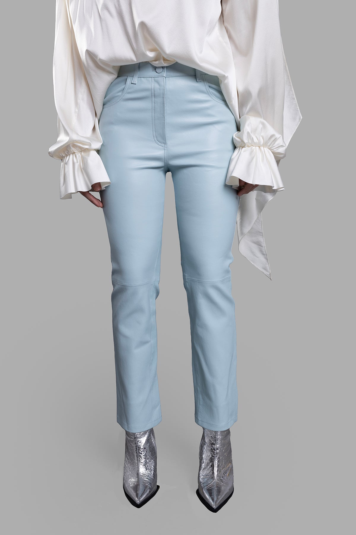 Joseph. Front view of straight-leg leather trousers in pastel blue, featuring a high waist and classic pockets, styled on.