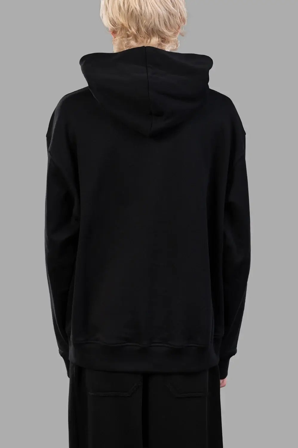 Front close-up of black hoodie showing tonal embossed logo and kangaroo pocket