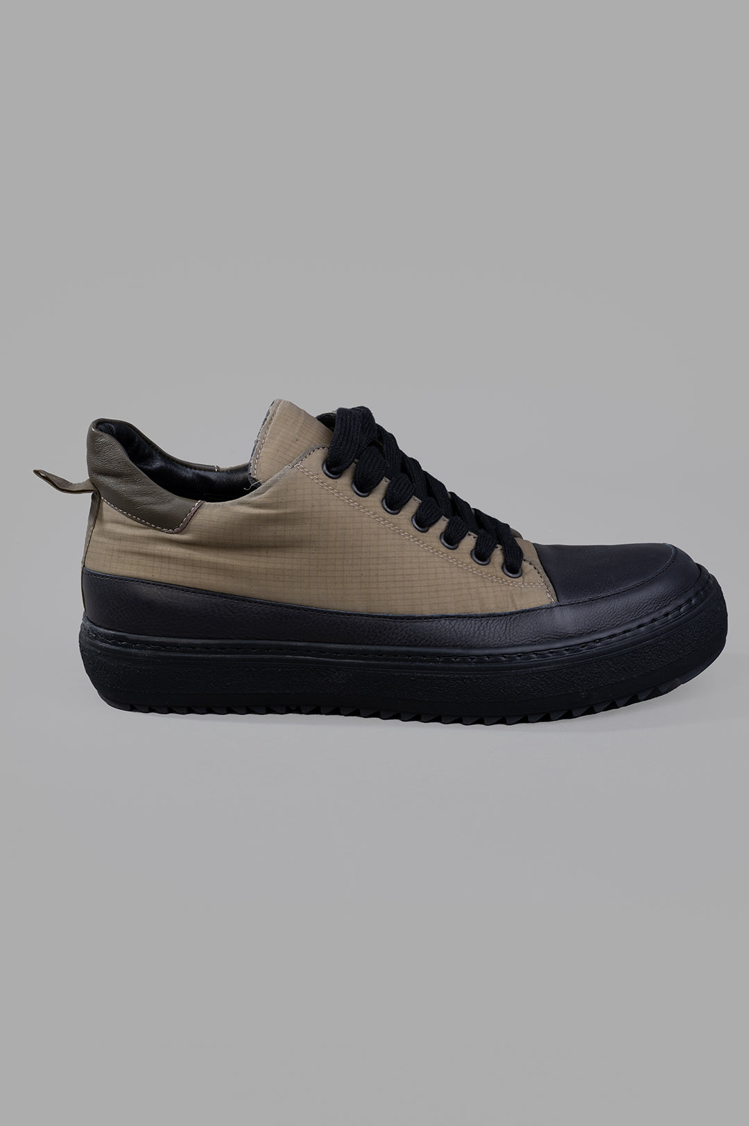 Masnada low-top sneakers side view featuring green cotton material with contrasting black nose, sole, and laces.