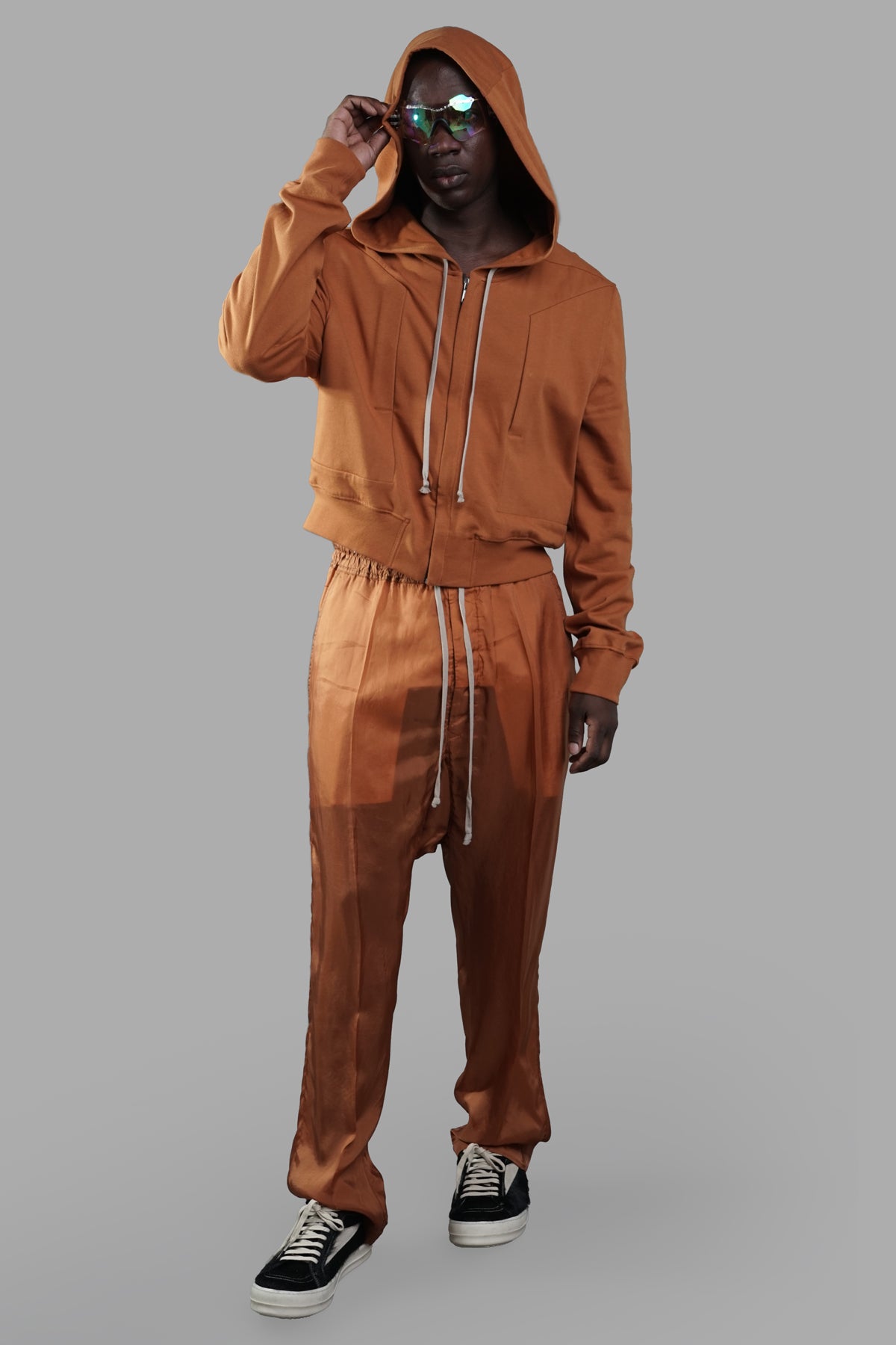 Rick Owens silk drop-crotch trousers, full-length, orange, on-model, with elasticized waistband and drawstring.