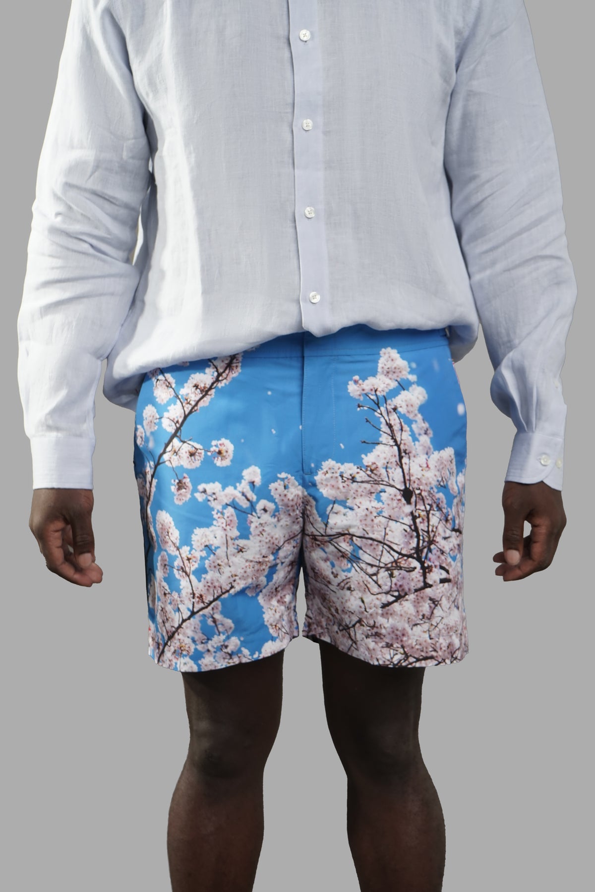 Orlebar Brown Blossom Mid-Length Swim Shorts, front view showcasing cherry blossom design on vibrant blue background.