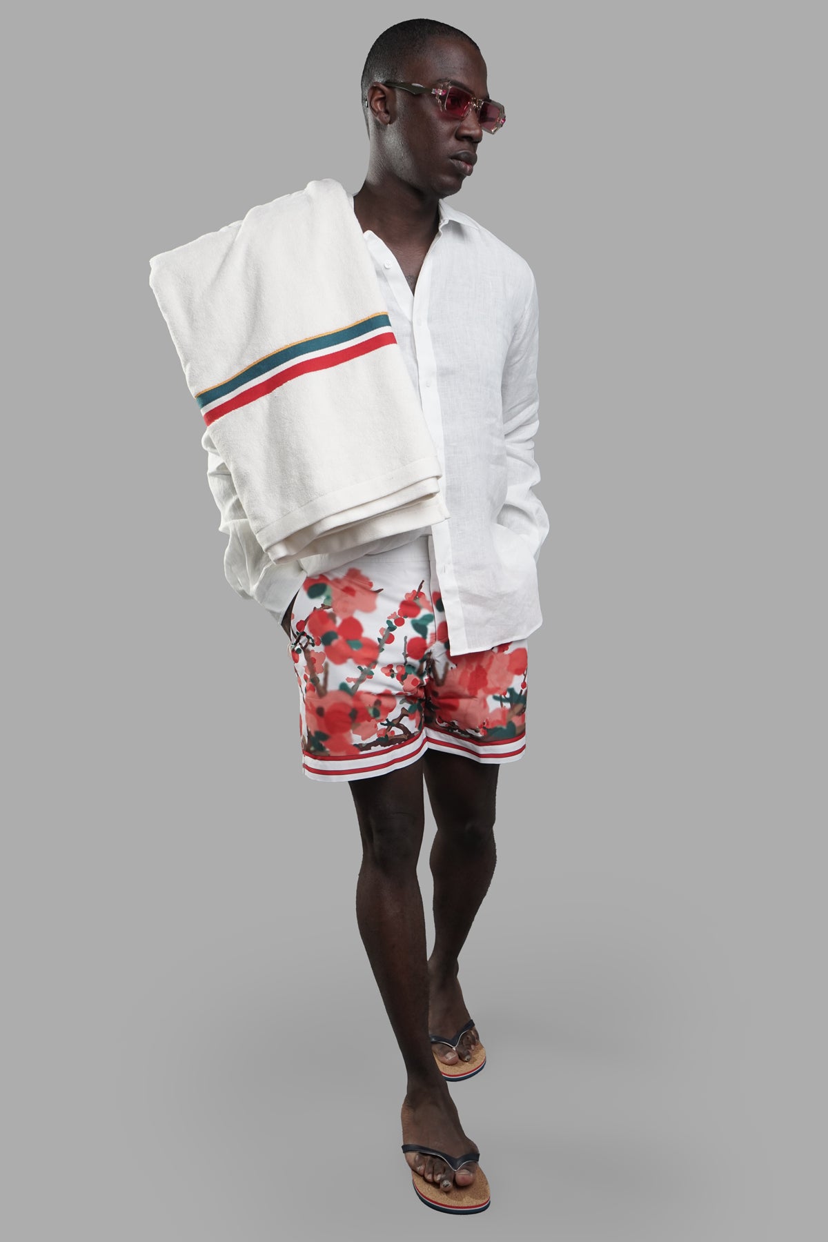 Orlebar Brown Blossom Swim Shorts front view on-model, styled with white shirt and towel draped over shoulder.