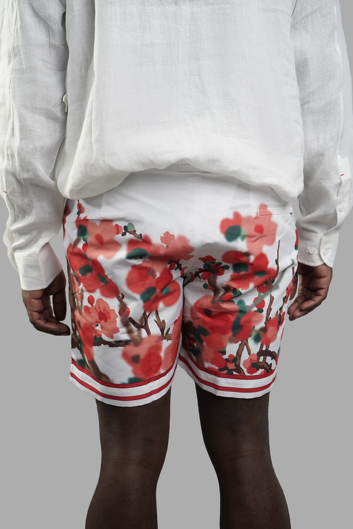 Orlebar Brown Blossom Swim Shorts in vivid floral print, showcased from the back on a model wearing a light shirt.