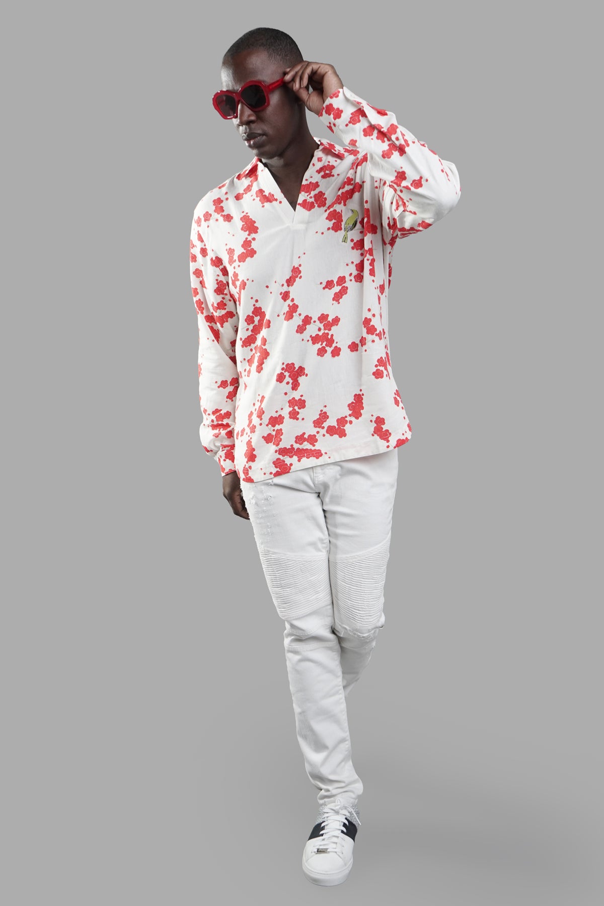 Orlebar Brown Blossom Overhead Shirt, front view on-model, red floral print on white, paired with white pants and sunglasses.