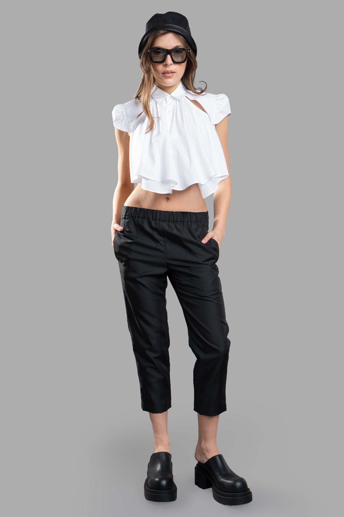Noir Kei Ninomiya Cropped Shirt with pleated front, cap sleeves, shown on-model, featuring open back and collar.