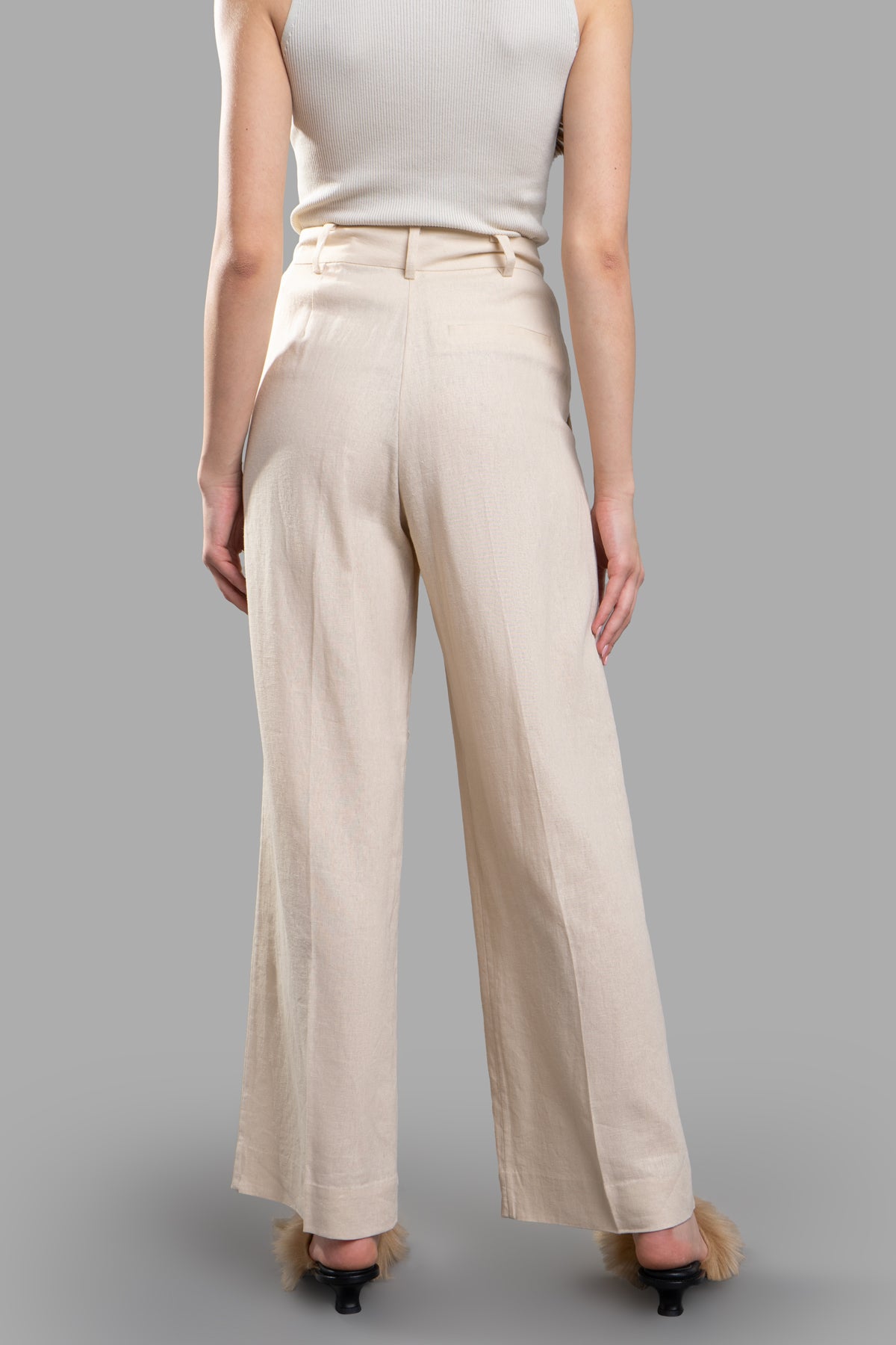 By Malene Birger High-waisted Trousers viewed from the back, featuring flared wide legs in beige linen-viscose blend.