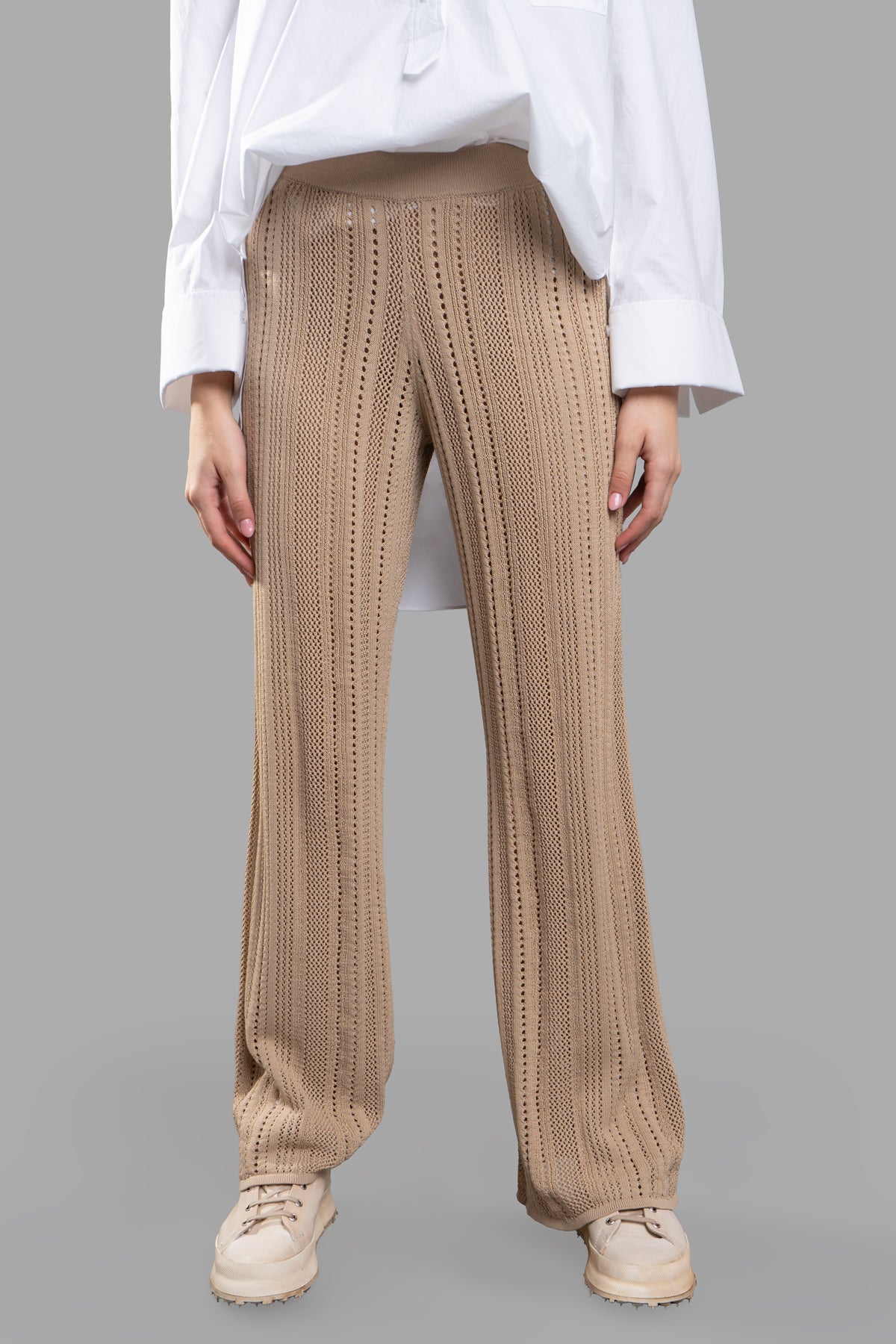 By Malene Birger Knit Trousers in beige, featuring a high-waisted and flared design, shown on model with white shirt.