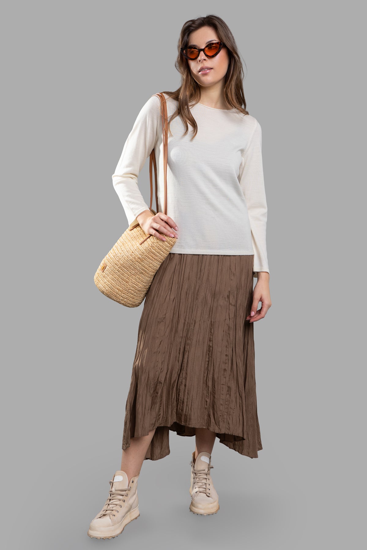 Comme des Garçons Fine-Knit Jumper on-model, ecru color, round-neck, paired with skirt, accessorized with sunglasses and bag.