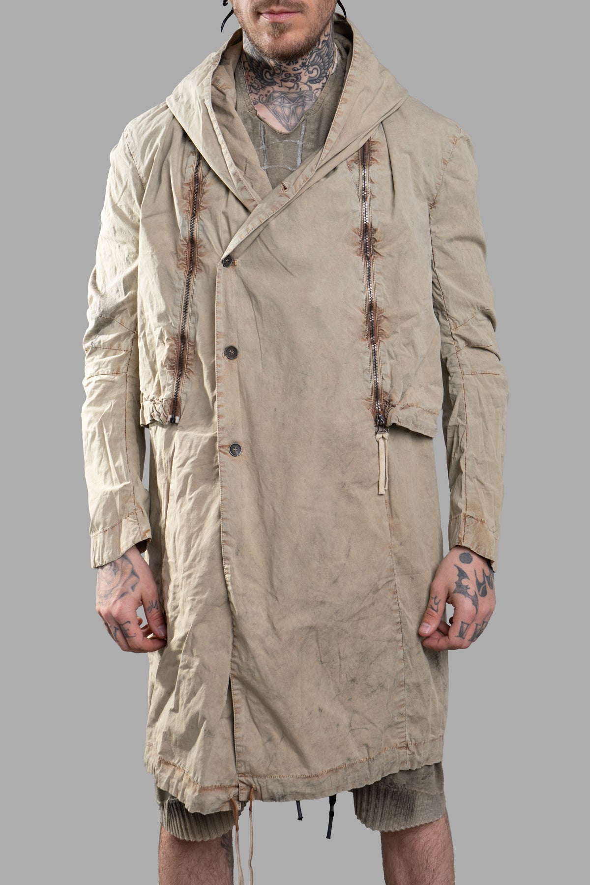 Masnada Transformative Linen Parka in beige, showcasing raised seams and versatility on model, styled as a longer jacket.