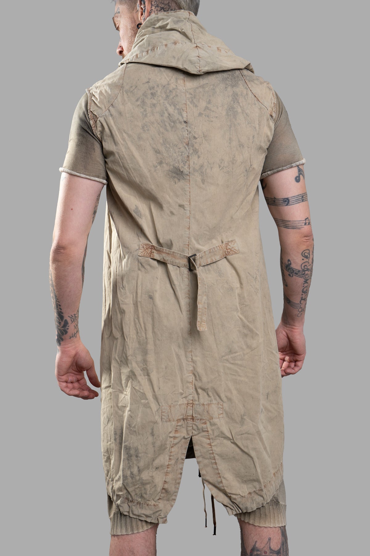 Masnada Transformative Linen Parka shown from the back, featuring a hood, raised seam detail, and adjustable waist ties.