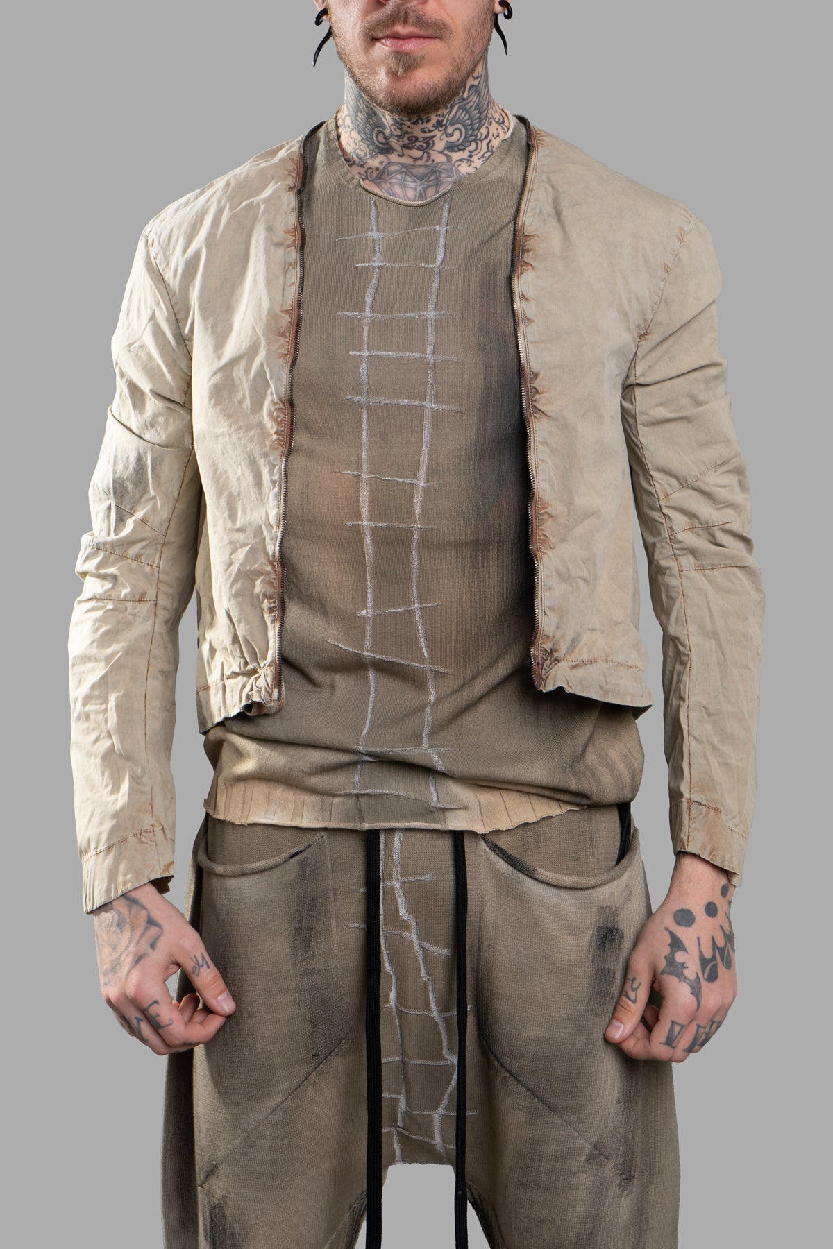 Masnada Transformative Linen Parka in beige, highlighting its unique draping and textured fabric from a side perspective.