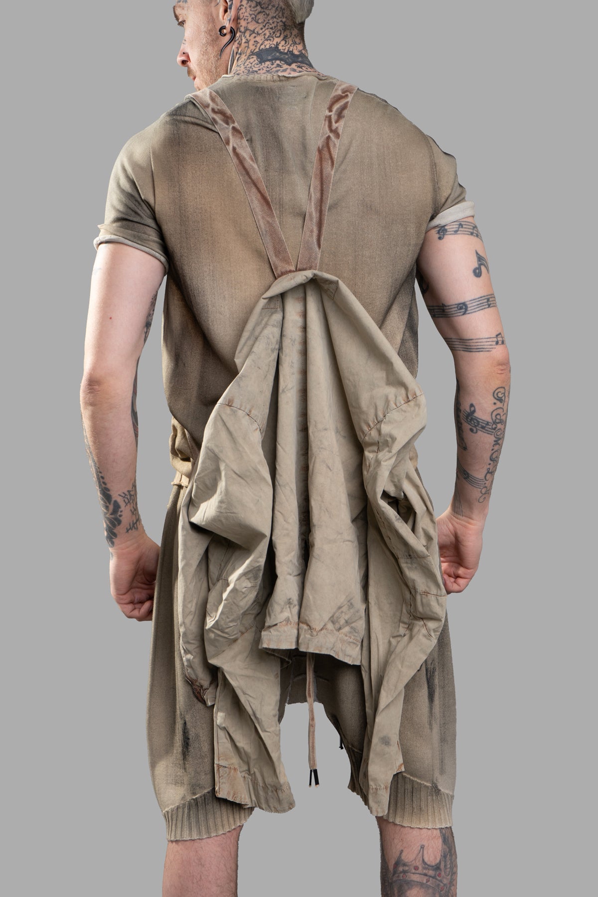 Masnada Transformative Linen Parka showcases a beige parka transforming style, featuring raised seam details and a relaxed.