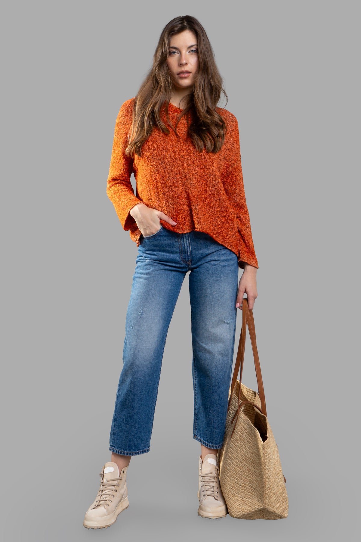 Avant Toi orange sweater, V-neck knit with asymmetric hem, worn by model, highlighting stylish and comfortable design.