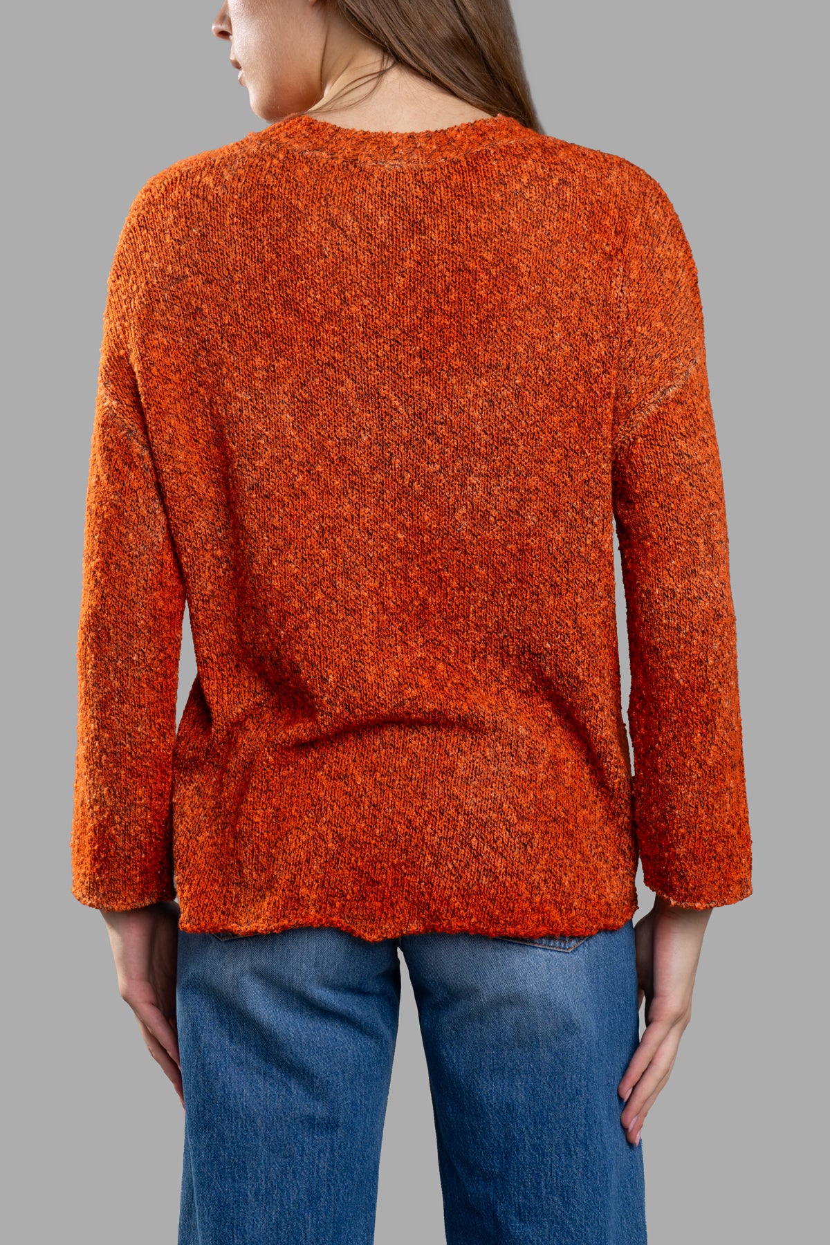 Avant Toi Orange Sweater featuring a cozy knit design, V-neck style, and asymmetric hem, shown from the back on model.