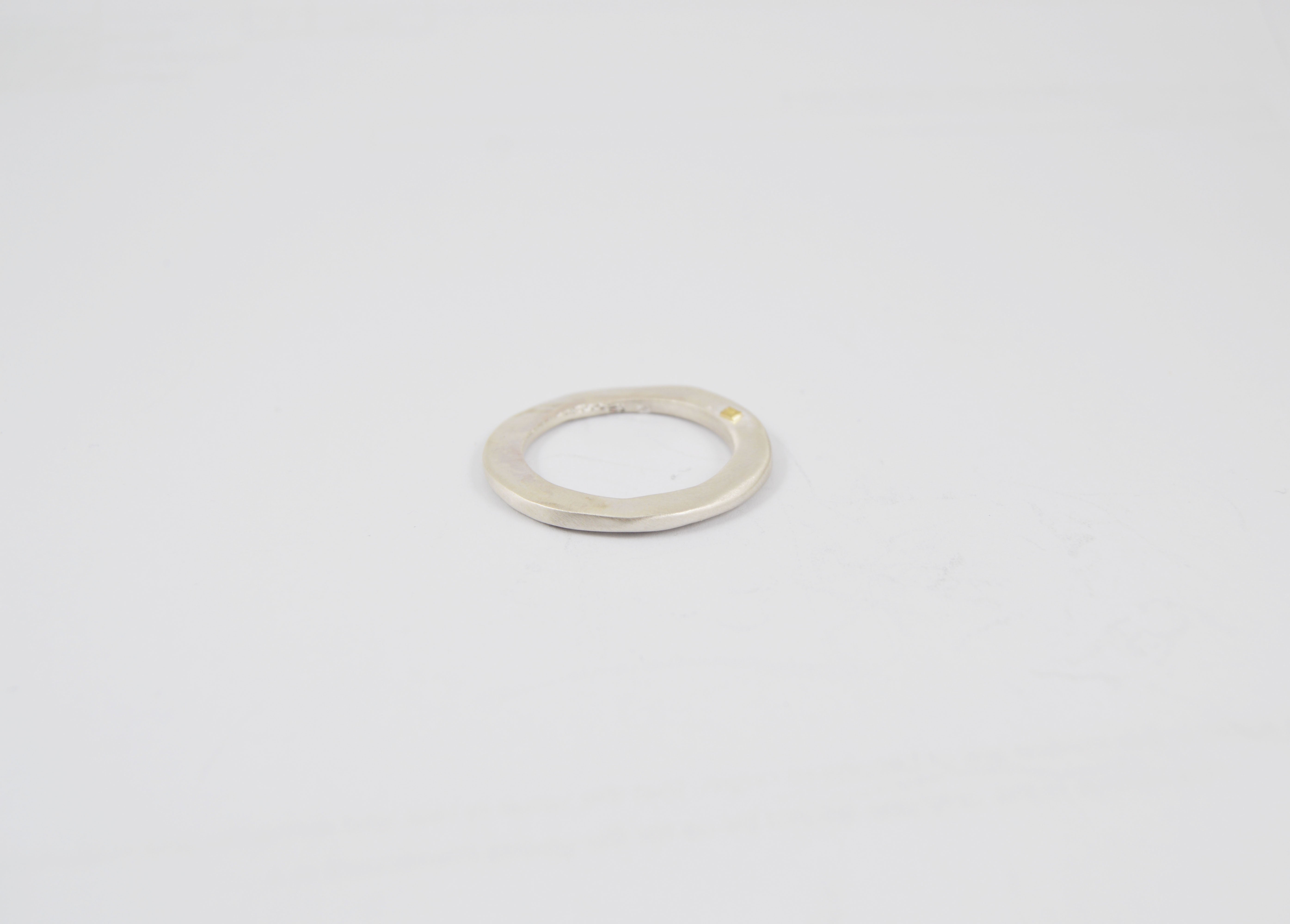 Rosa Maria Haz Ring featuring a handmade silver design with textured surface and a cognac diamond accent, displayed on a.