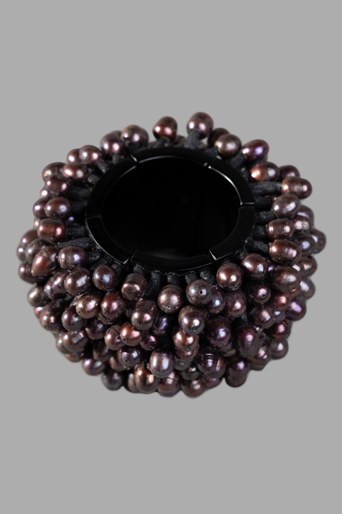 Monies statement bracelet in black, featuring oversized beads of ebony wood and black pearl. Close-up view.