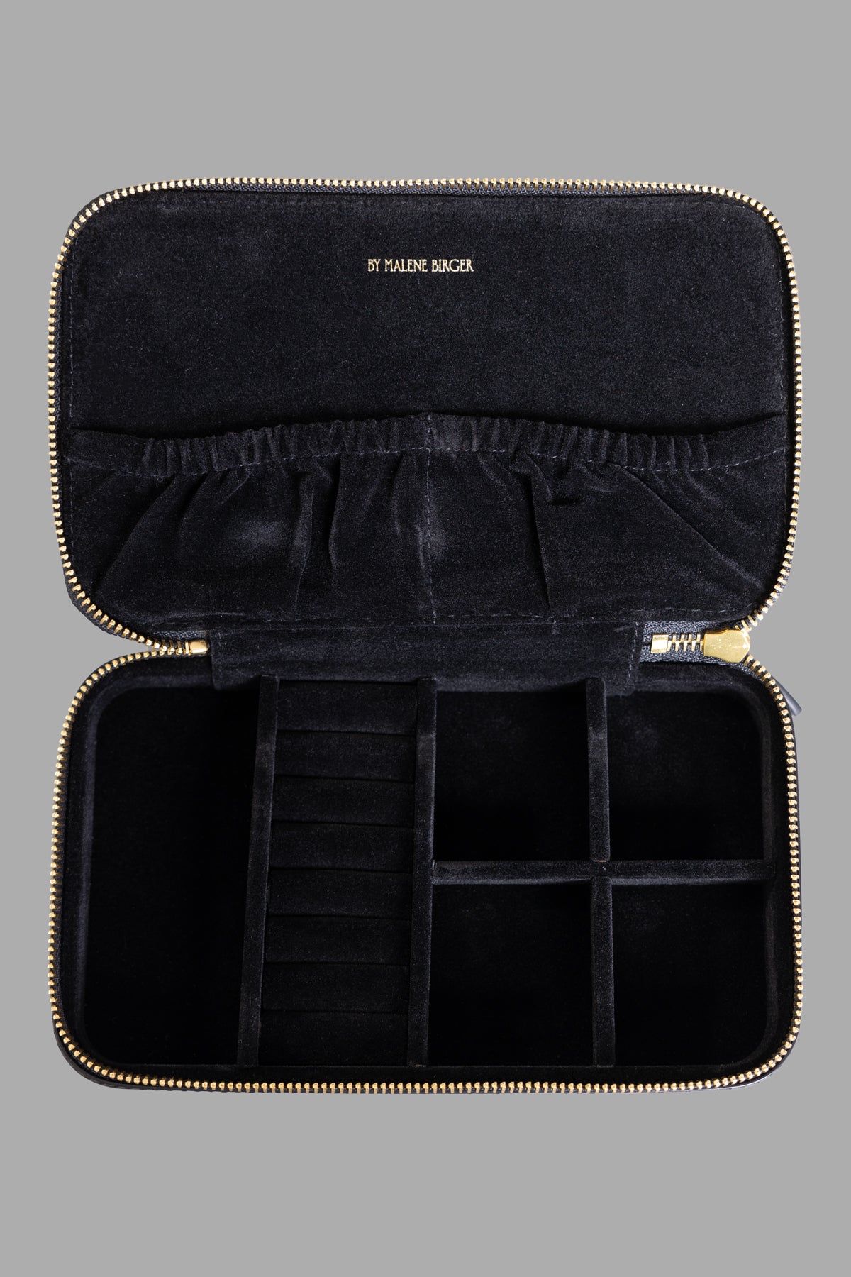 By Malene Birger Leather Beauty Case interior view, featuring organized compartments and soft black lining for cosmetics.