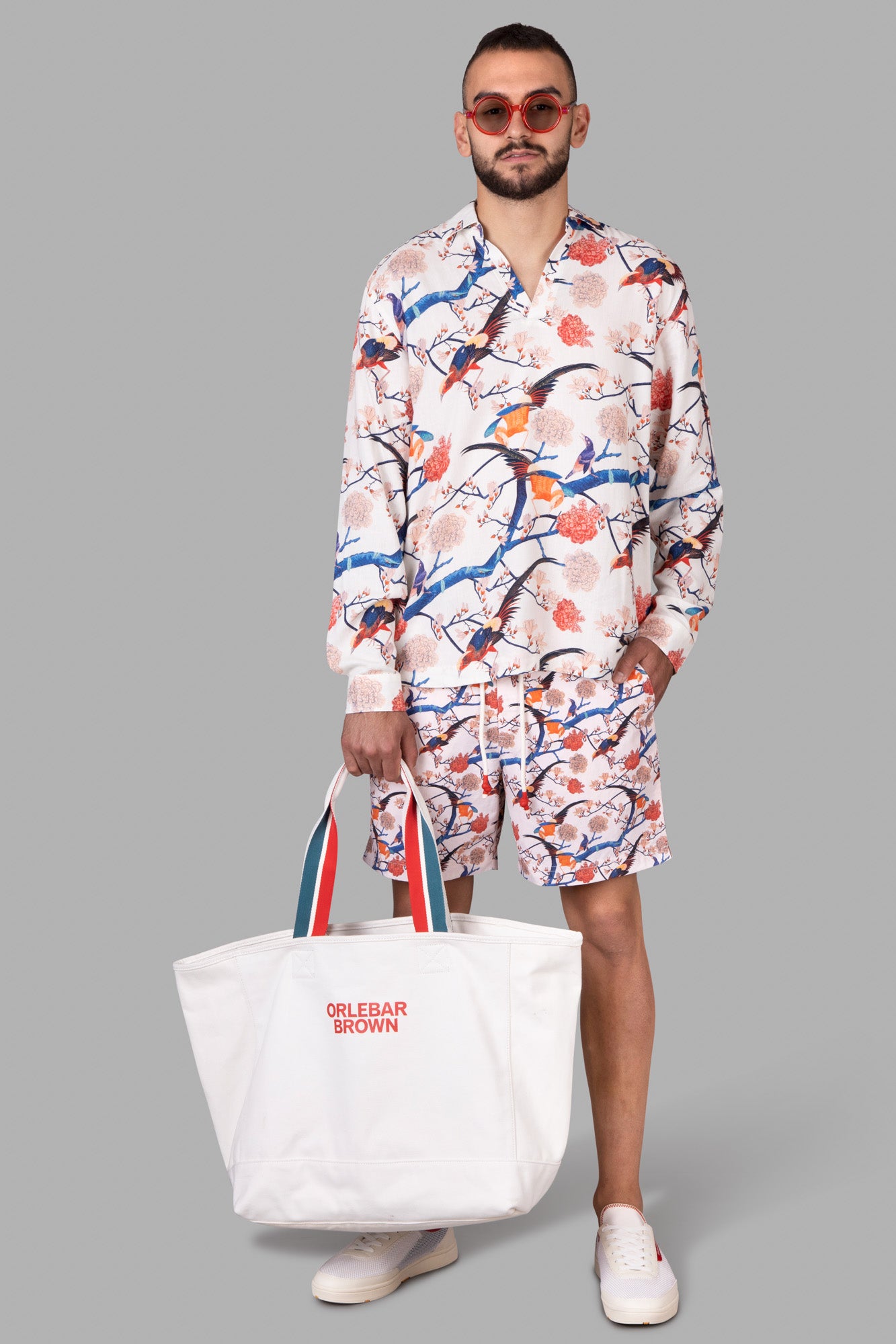 Orlebar Brown Mid-Length Swim Shorts, vibrant floral print, front view, paired with matching shirt and tote bag.