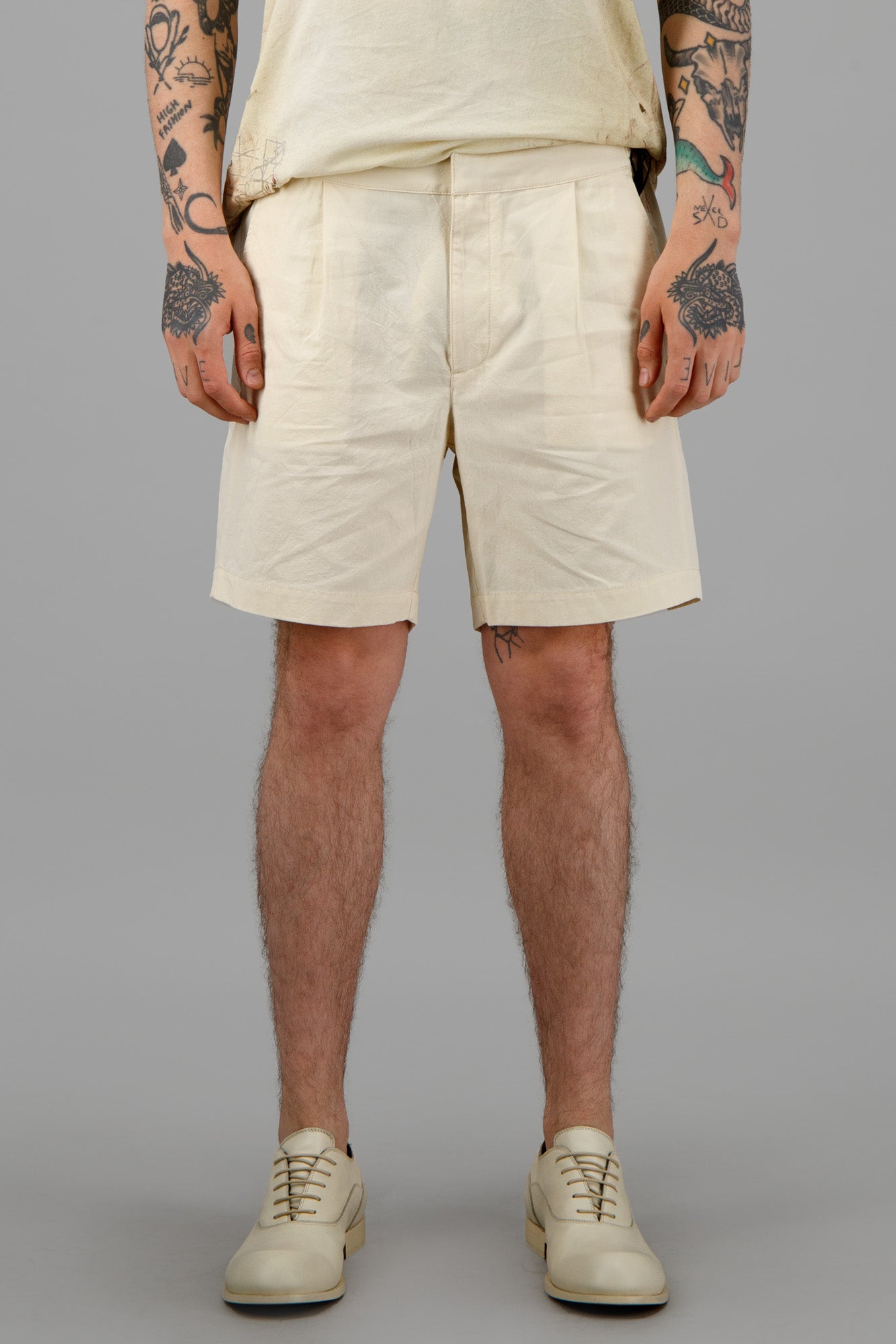 Orlebar Brown Sand-Colored Shorts featured in White Sand, showcasing comfortable fit and classic pleat design on model.