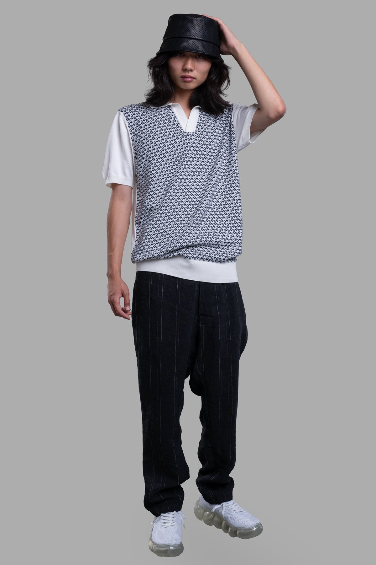 Orlebar Brown Knit Polo Shirt front view, featuring navy mosaic pattern and white collar, sleeves on model, color.