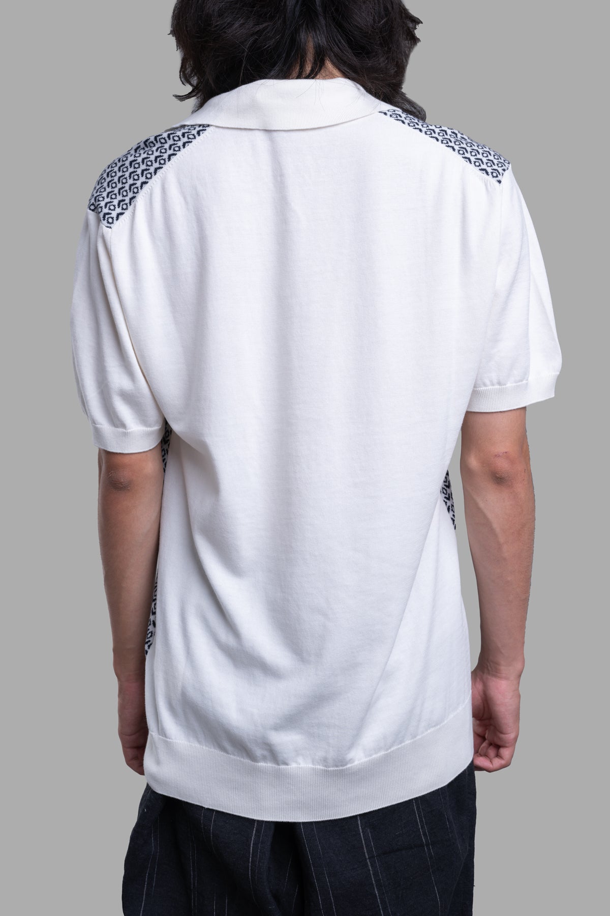 Orlebar Brown Knit Polo Shirt, white with navy mosaic pattern, showcasing back details and ribbed edges. 100% cotton.